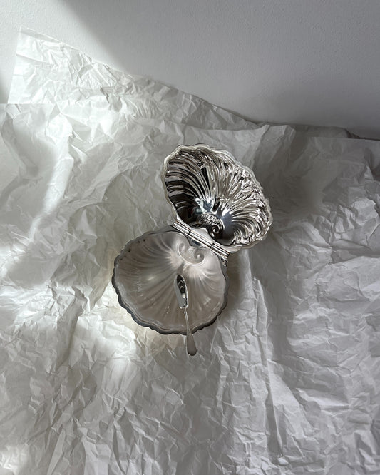 Close-up of the graceful clam-shaped design on the 1930s English silver-plated butter/caviar dish, exuding refined coastal charm.