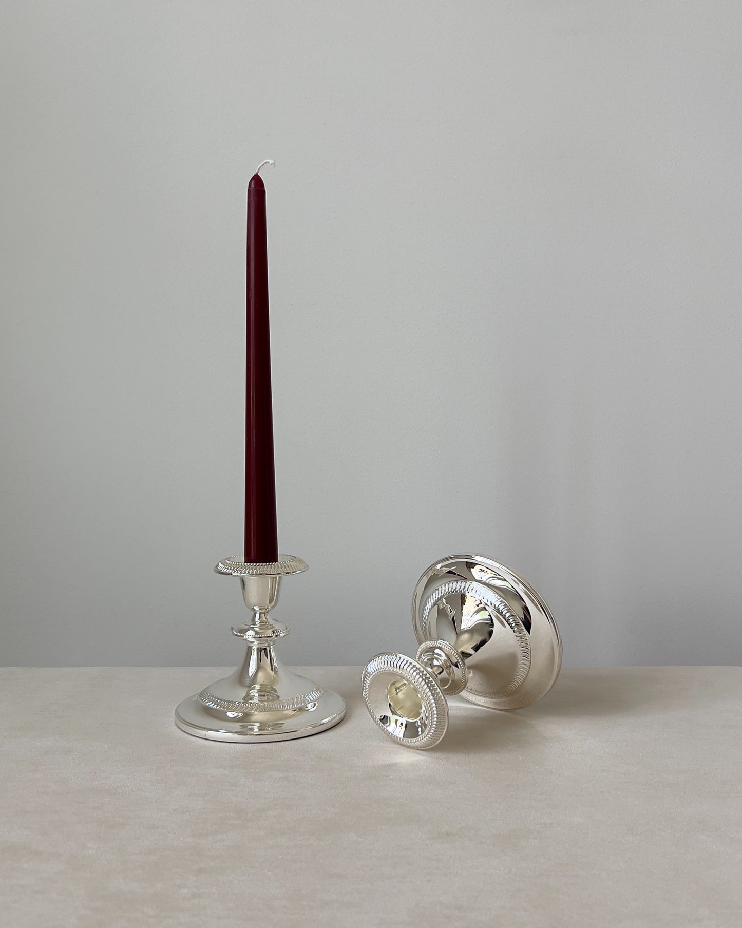 A pair of elegant mid-century silver-plated candlesticks shown together, highlighting their graceful silhouettes and lustrous finish. Made in West Germany.
