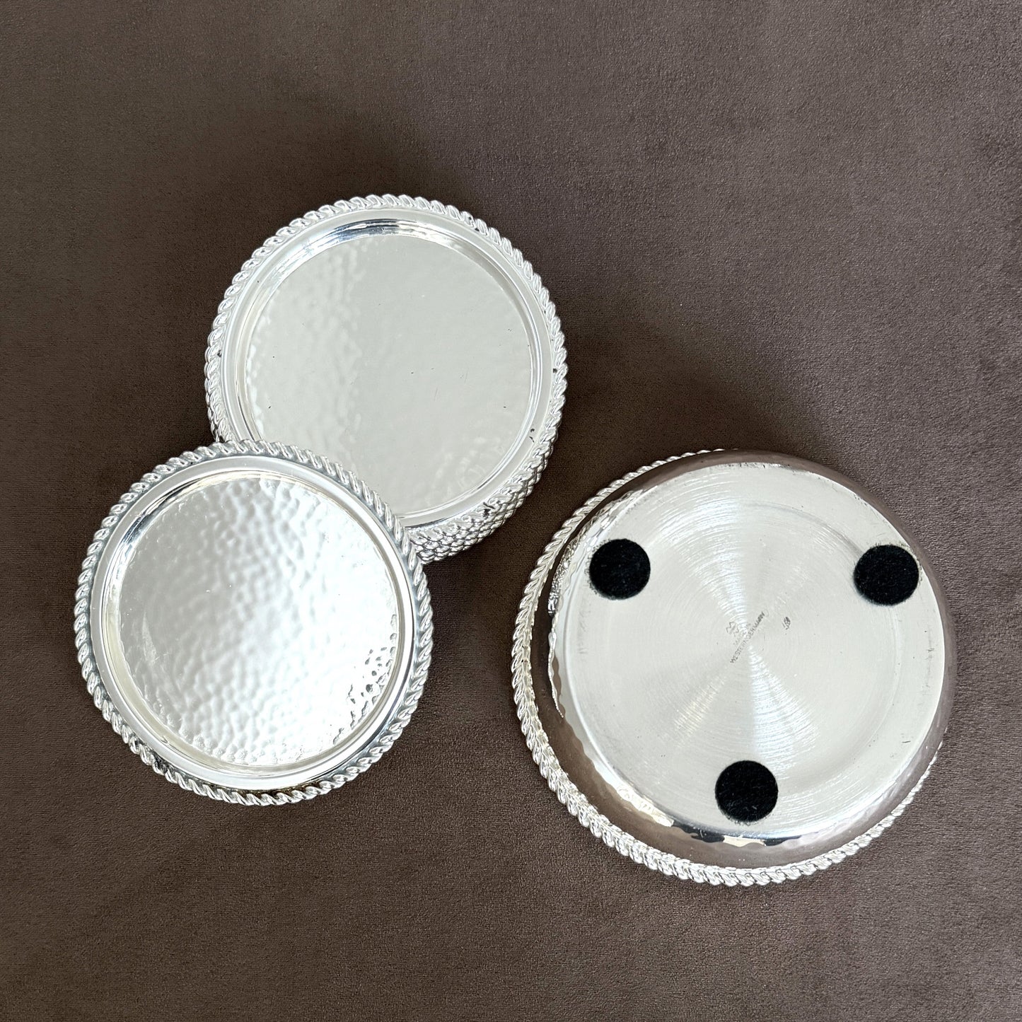 A side profile of the rare West German silver-plated coaster set, showing the significant weight and substantial build of the 1960s barware.