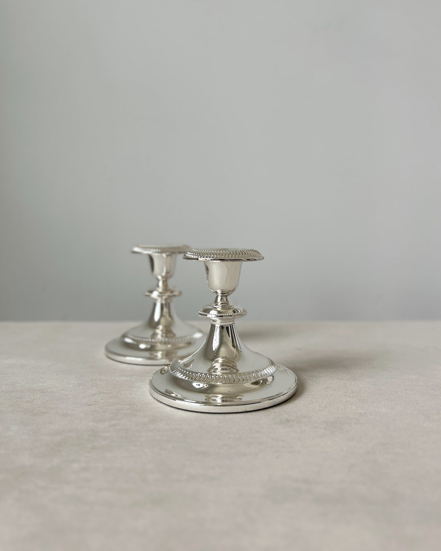 A styled photo showing the set of 2 German silver candlesticks as a sophisticated decorative accent on a console table, enhancing the home decor.