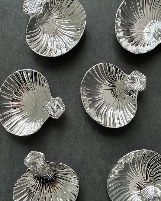 Close-up of vintage silver shell dish edge, highlighting scallop ridges and lustrous silver plating in excellent condition.