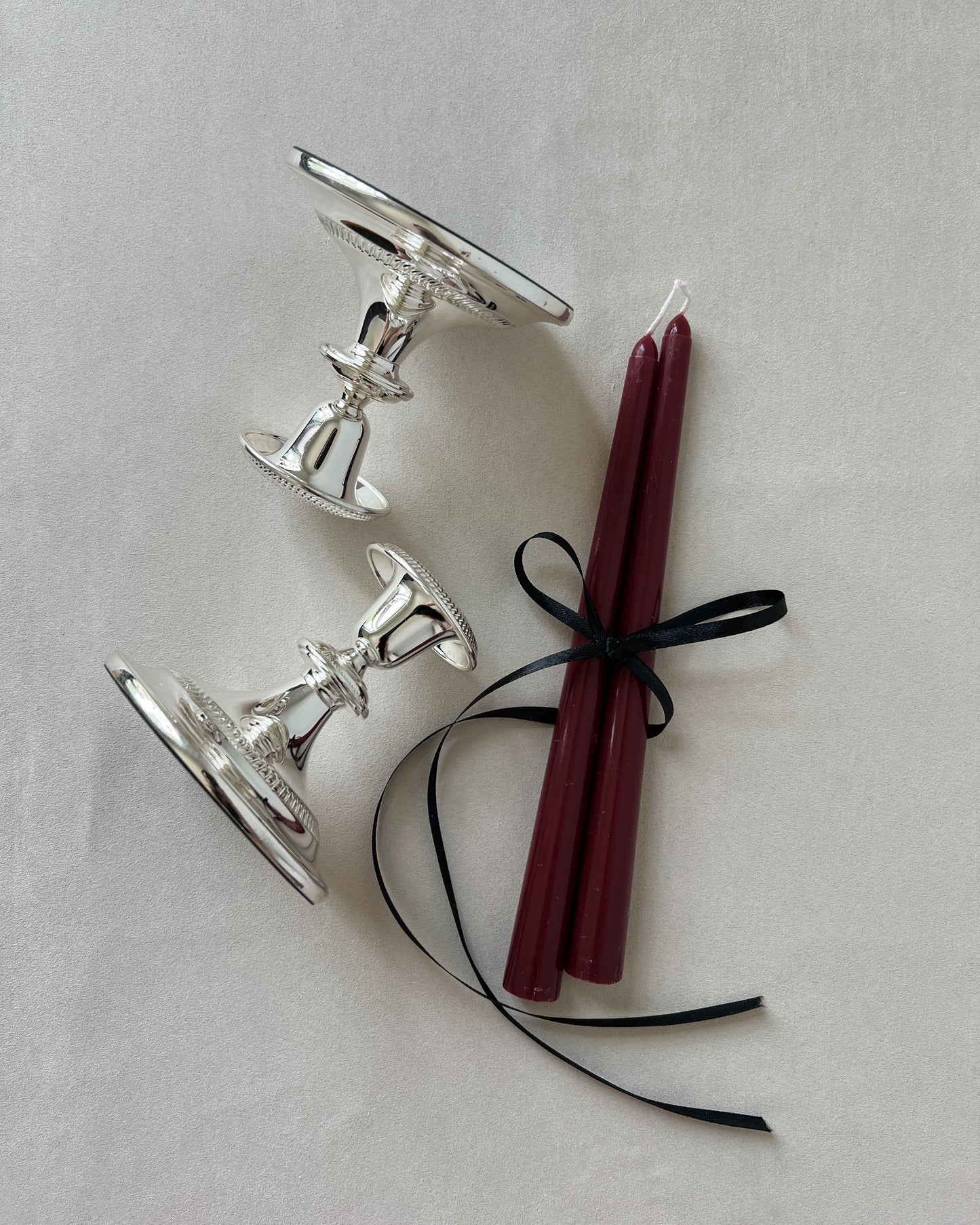 Close‑up of mid‑century silver‑plated candlestick silhouette showcasing elegant tapered profile and reflective finish.