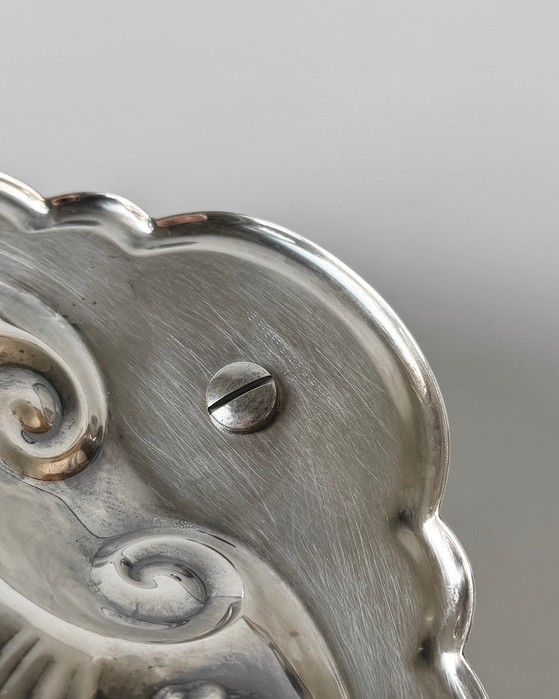 The underside of the vintage centerpiece showing the authentic engraved Sheffield hallmark, ensuring its pedigree as high-quality American silver plate.