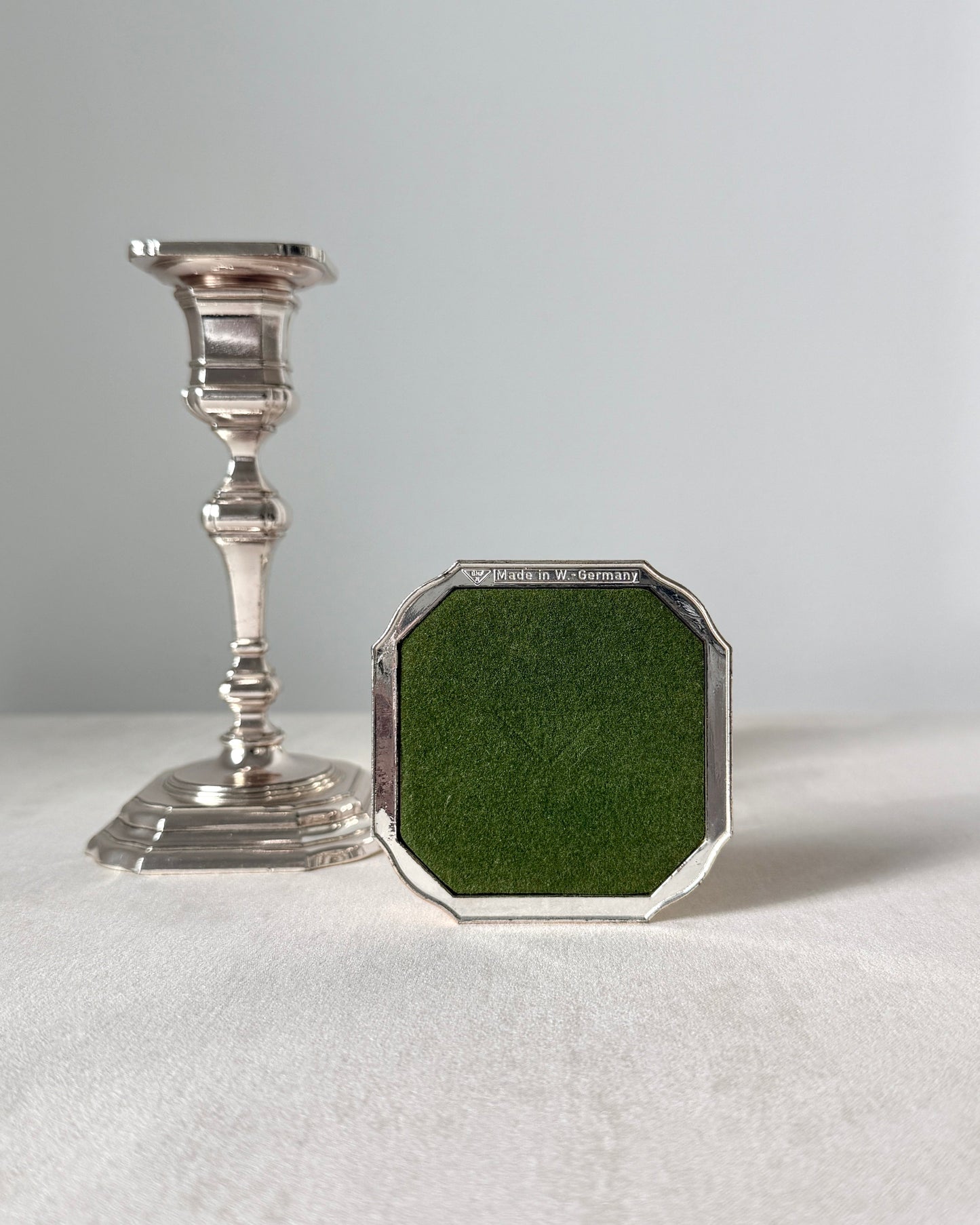The bottom of the BMF candlestick showing the authentic "BMF N Made in W. Germany" hallmark and the green protective pad on the square base.