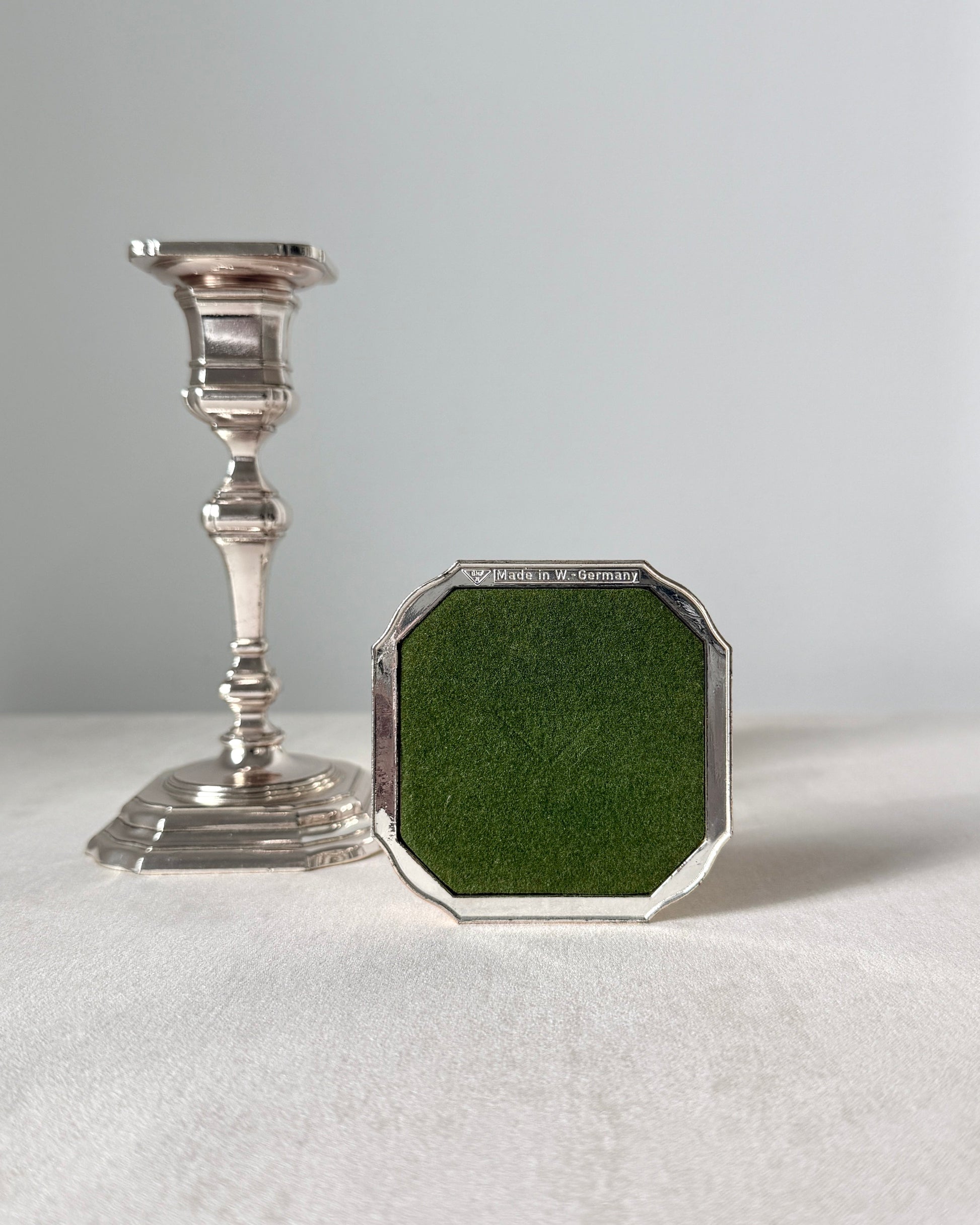 The bottom of the BMF candlestick showing the authentic "BMF N Made in W. Germany" hallmark and the green protective pad on the square base.