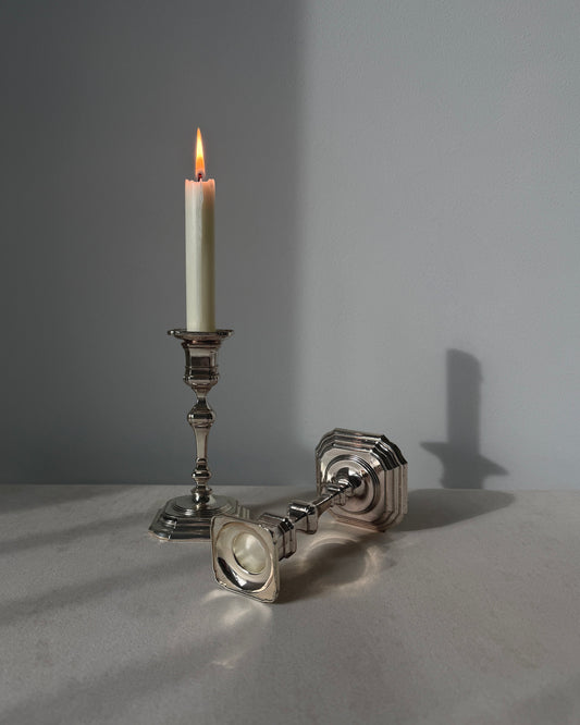 A pair of vintage BMF silver-plated candlesticks with a sleek mid-century modern design and weighted square bases, made in West Germany.