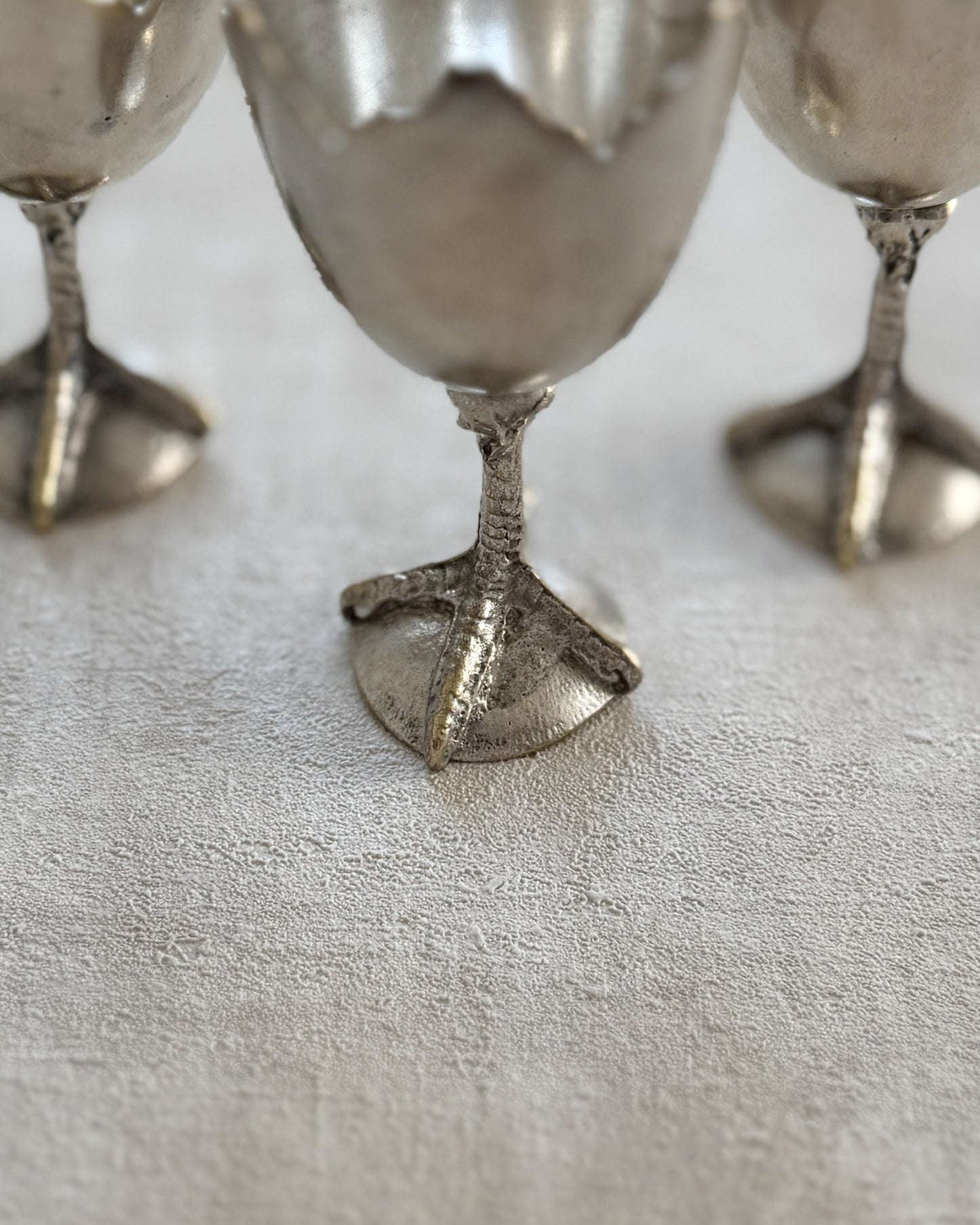 A detailed close-up of the high-relief chicken foot stem, showcasing the intricate organic modern textures and high-quality silver-tone metalwork.