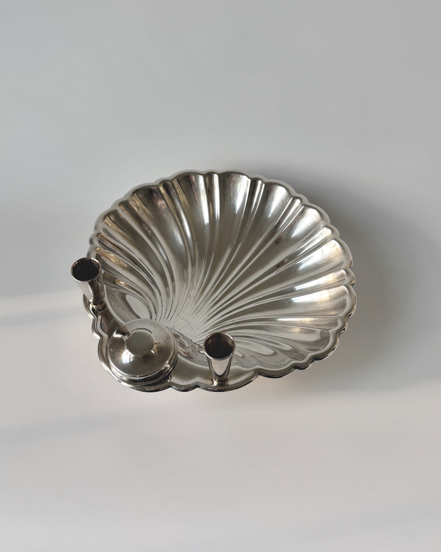 A perspective shot of the Sheffield shell candlestick holder, showcasing its coastal grandmother and regency-inspired elegance for a formal buffet or mantel.
