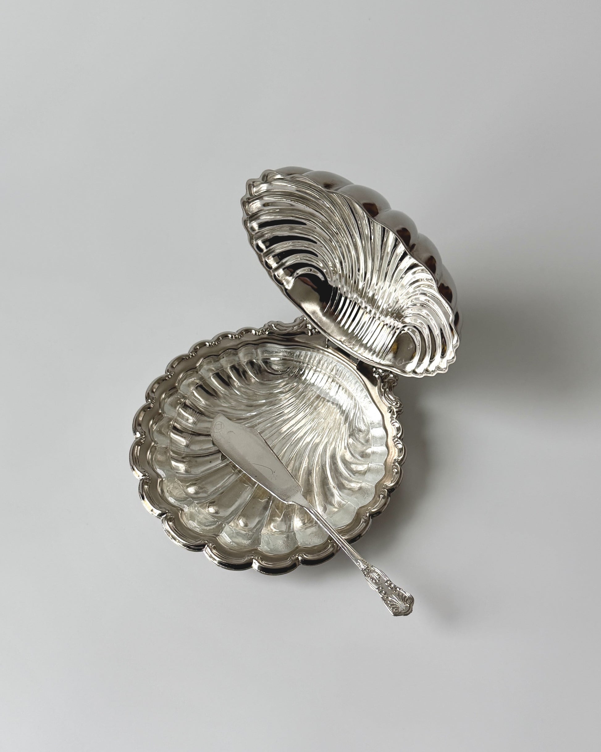 Detailed view of the matching coastal-themed spreader knife included with the silver shell set, perfect for high-end hosting and condiments.