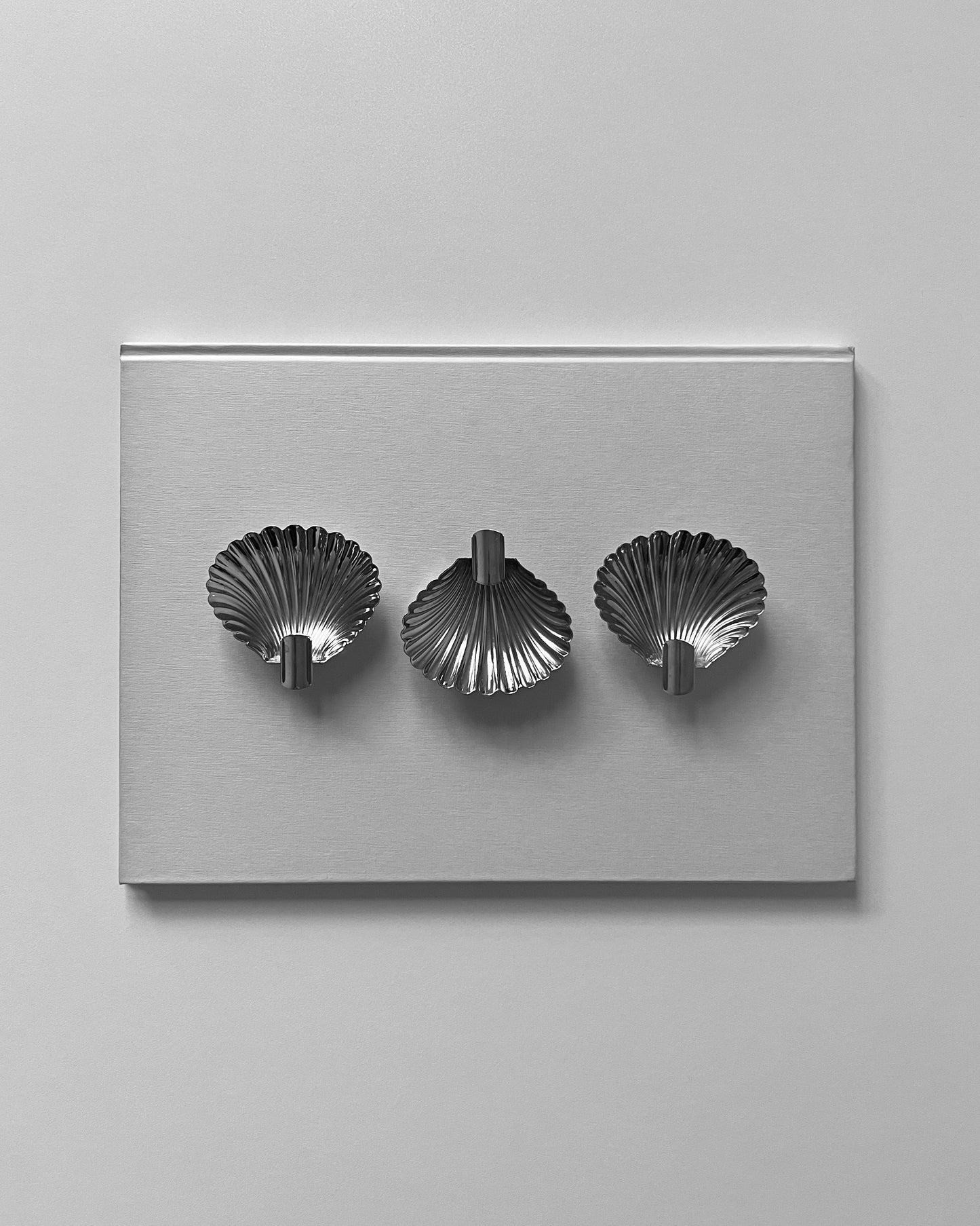 A detailed close-up of the 1950s Italian shell ashtray, showing the thoughtfully designed cigarette rest and the texture of the silver.