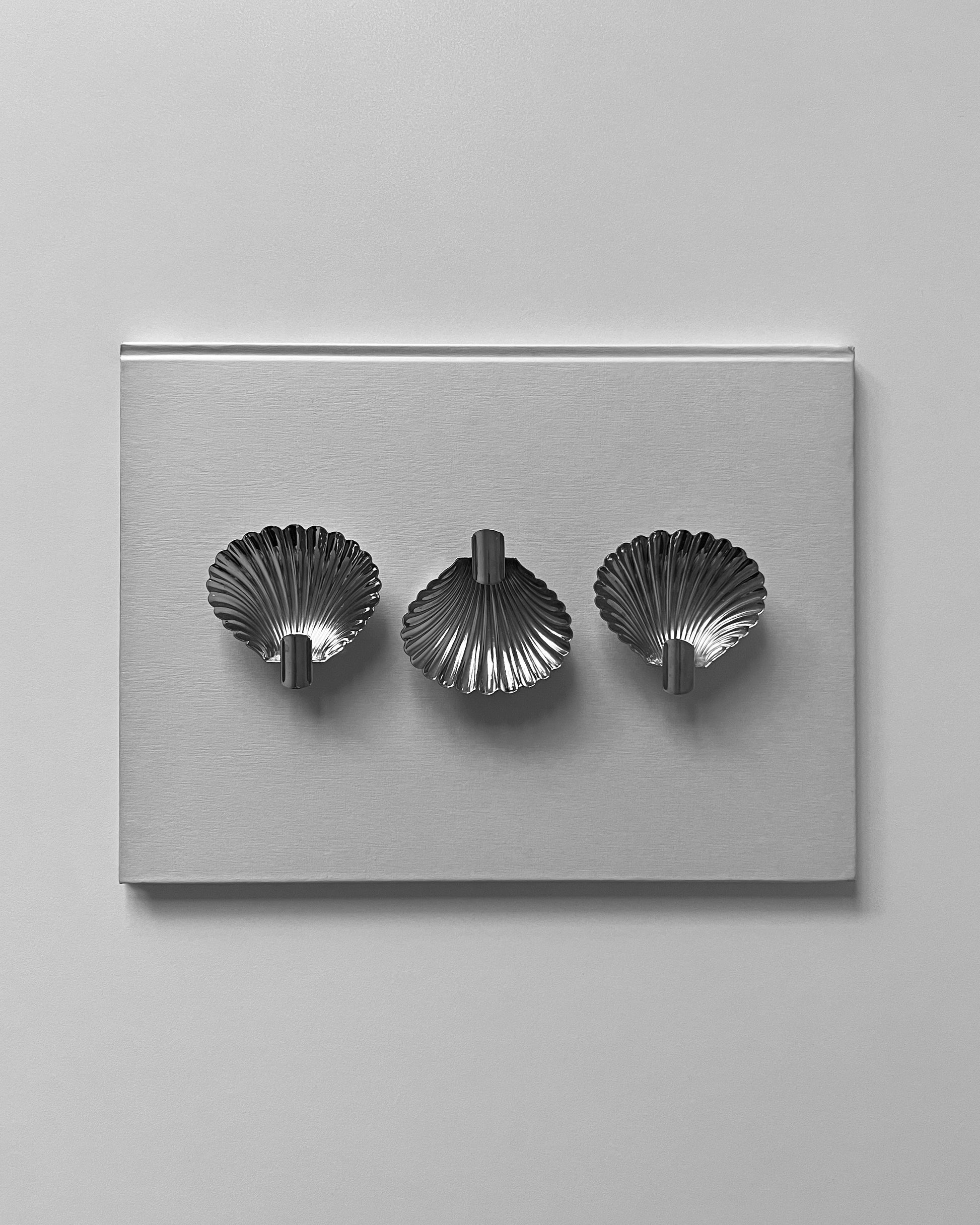 A detailed close-up of the 1950s Italian shell ashtray, showing the thoughtfully designed cigarette rest and the texture of the silver.