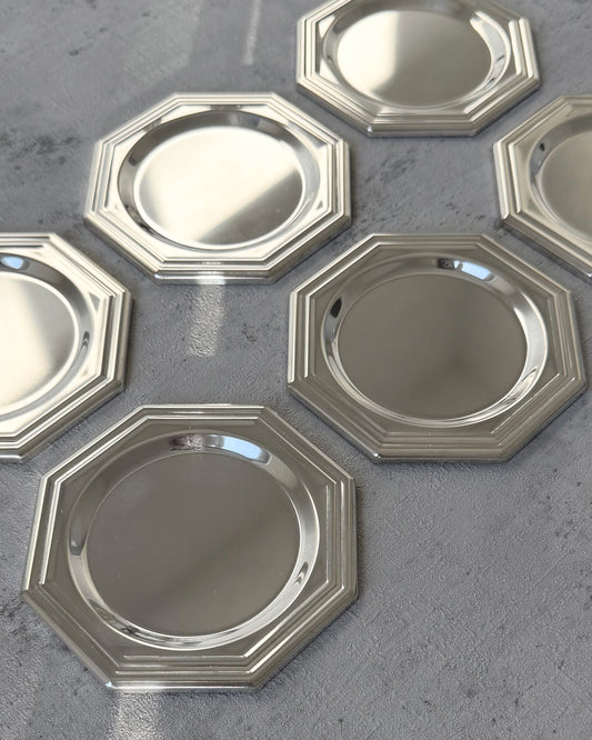 A detailed view of the eight-sided octagonal geometry and sharp architectural lines of a single vintage 1980s silver-plated coaster.