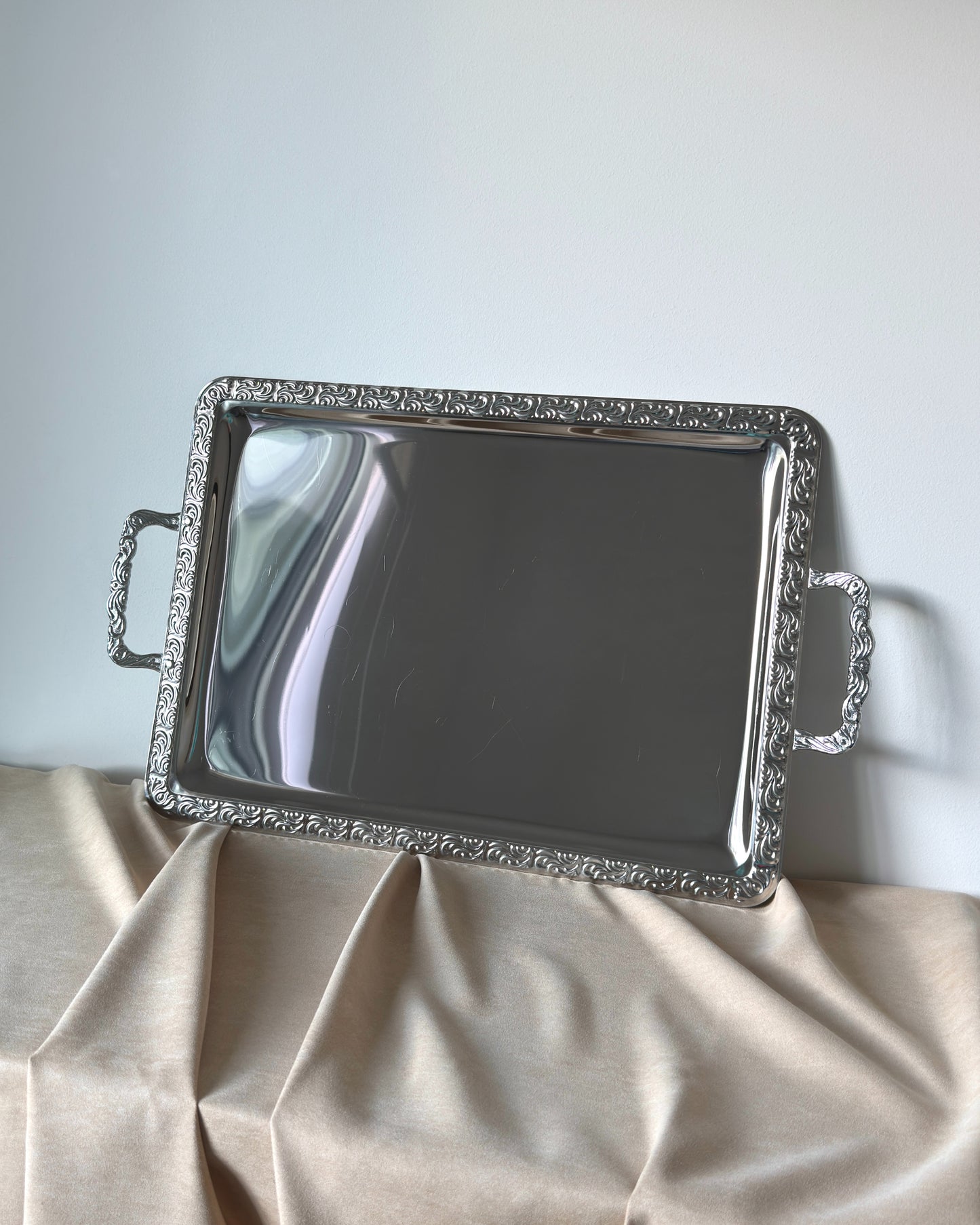 A high-angle shot capturing the brilliant factory luster and mirror-like reflection of the unused glossy stainless steel surface on this vintage German tray.