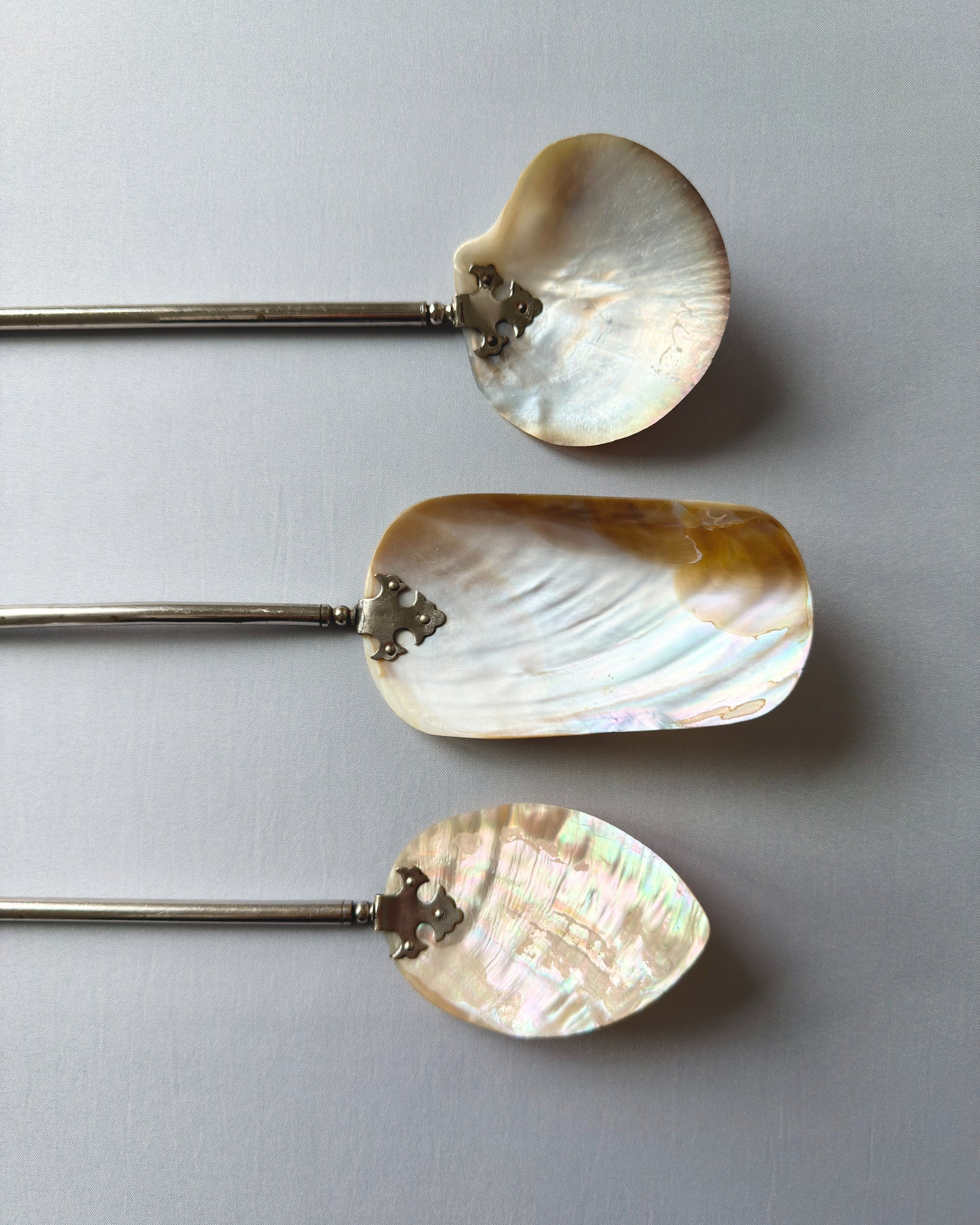 Close-up of the natural mother-of-pearl shell tops, highlighting the shimmering honey and cream iridescent tones and unique organic texture of the antique set.