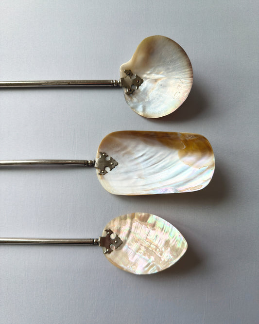 Close-up of the natural mother-of-pearl shell tops, highlighting the shimmering honey and cream iridescent tones and unique organic texture of the antique set.