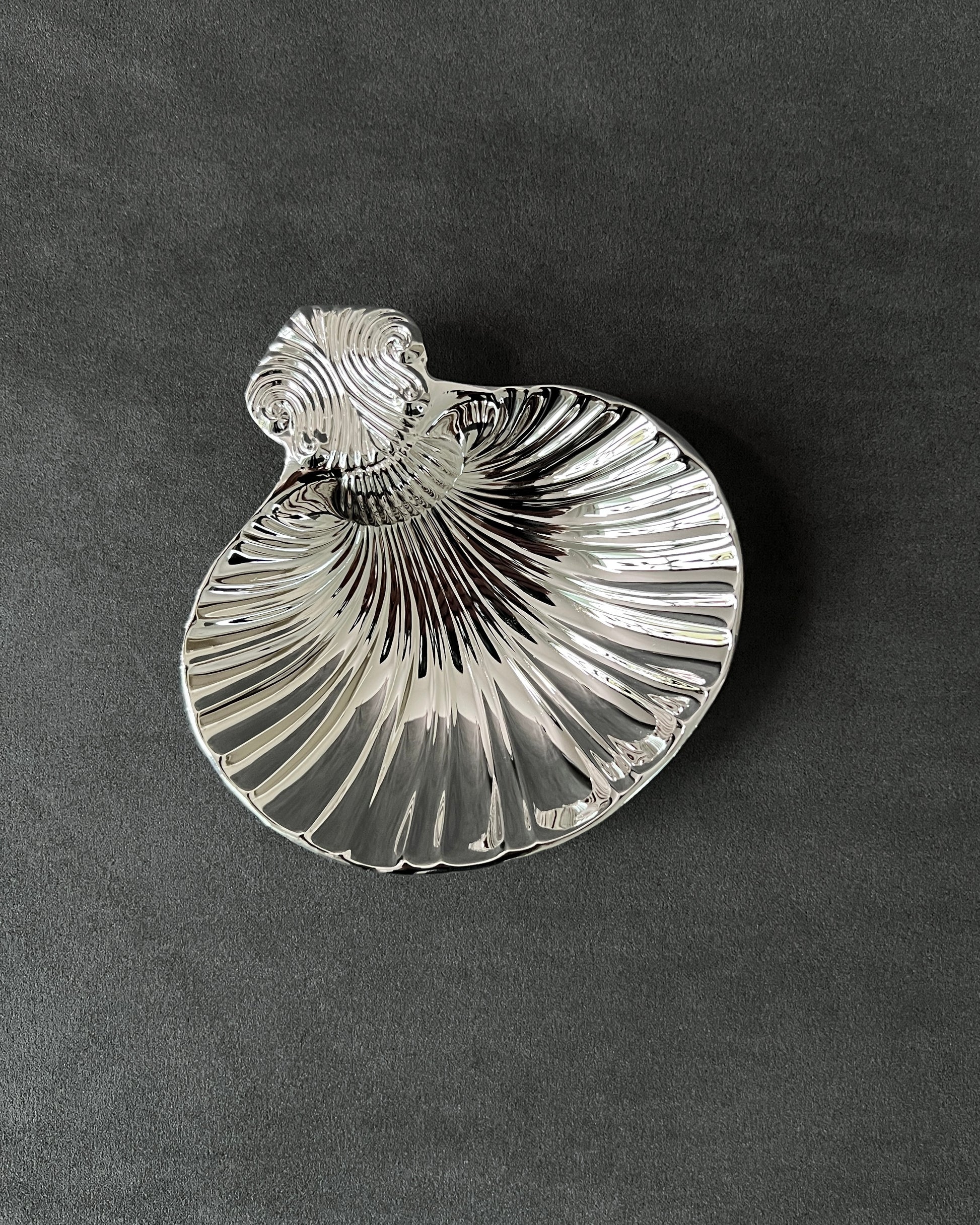 Vintage silver-plated shell dish holding caviar, demonstrating functional use as elegant server for appetizers and desserts.