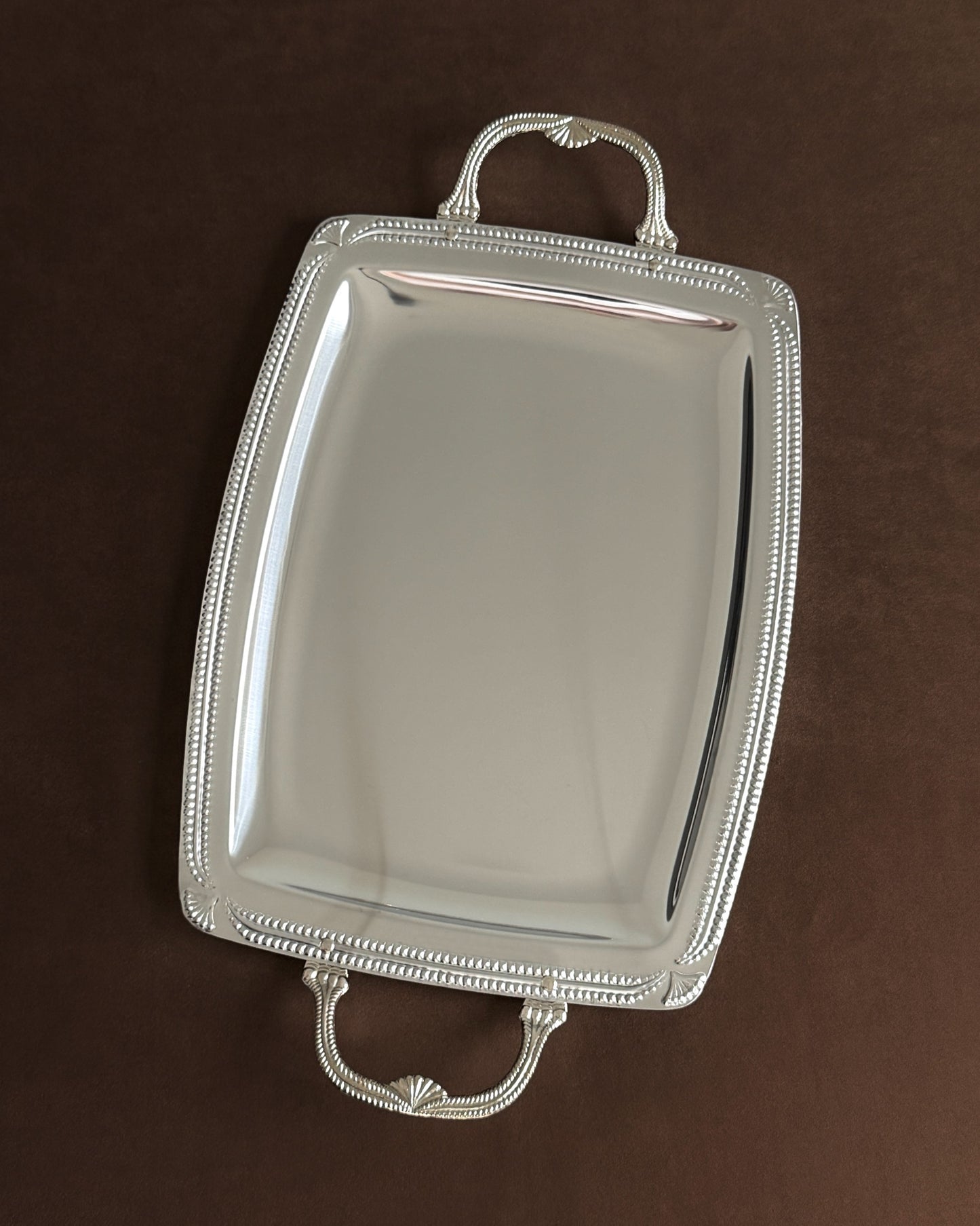 An angled shot of the polished silver-plated tray, capturing its reflective surface and sophisticated Mid Century aesthetic, ideal for a vanity or cocktail service.