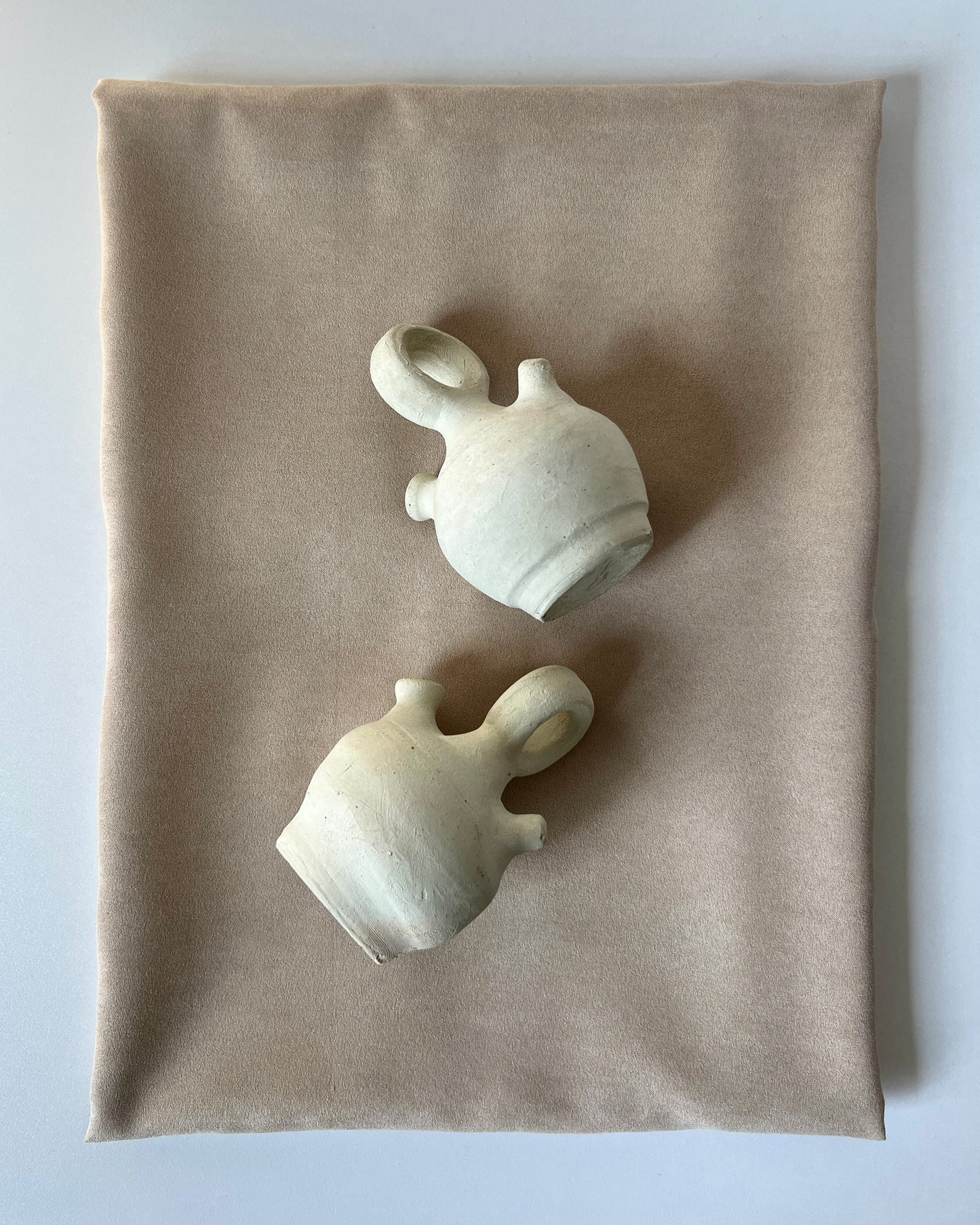 Small in size vintage Spanish botijo water jug made of unglazed natural clay from the 1970s, showcased front-on against a white background, highlighting its bulbous body, narrow spout, and traditional Búcaro design for cooling water naturally.