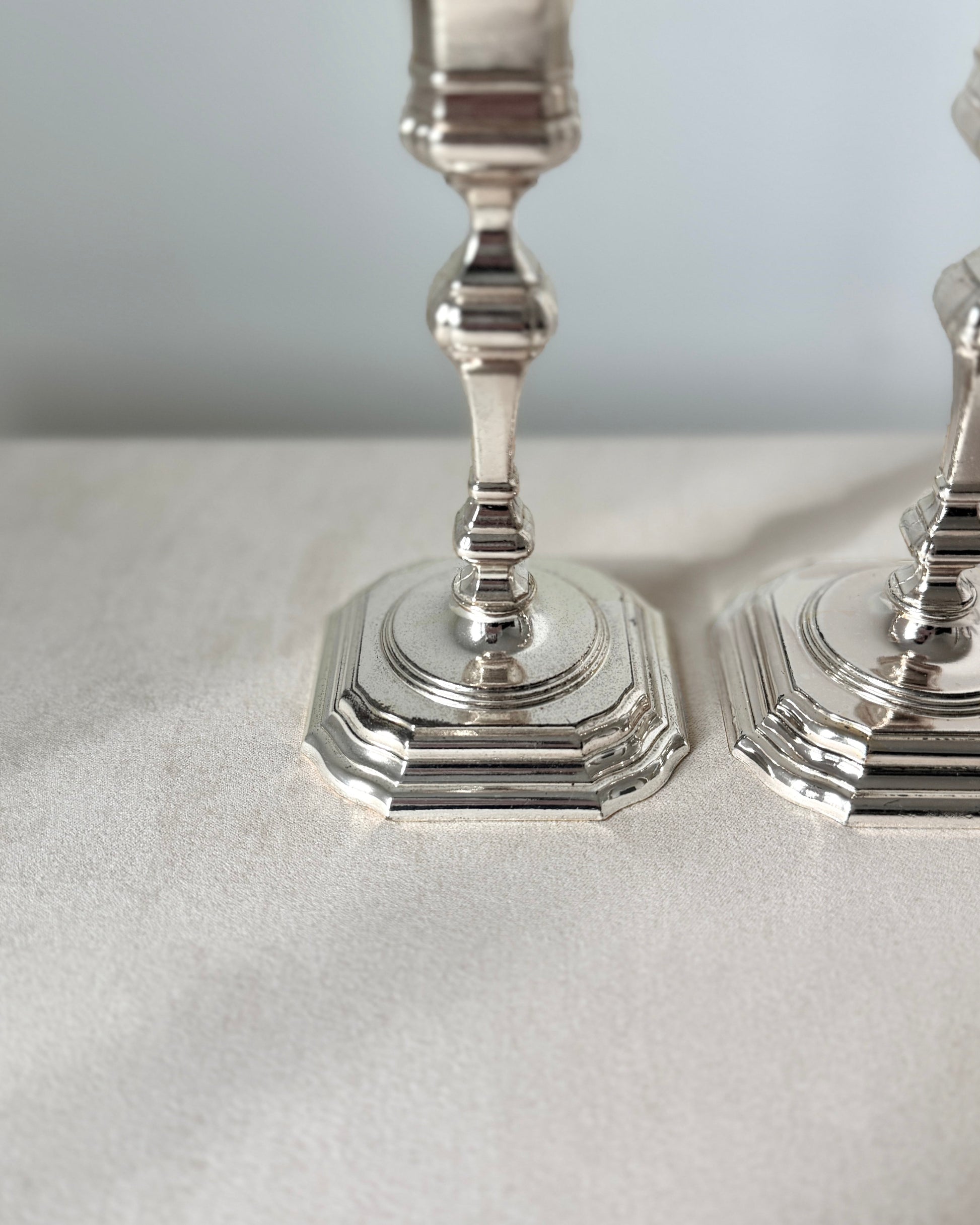 Detailed view of the sculptural, space-age silhouette of the BMF silver-plated taper candle holders, highlighting the high-quality mirror finish.