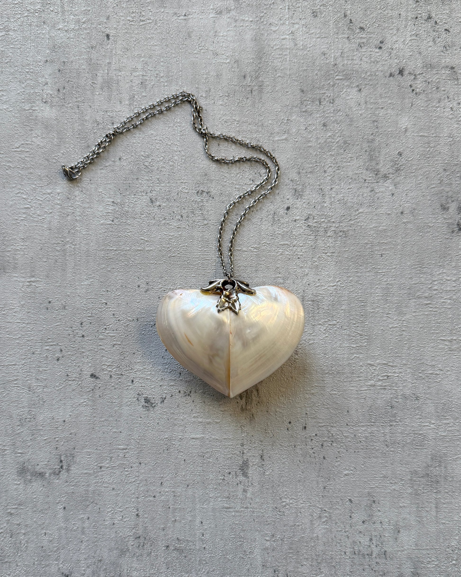 Back profile of the antique heart trinket box pendant, showing the depth of the shell construction and the secure lidded closure mechanism.