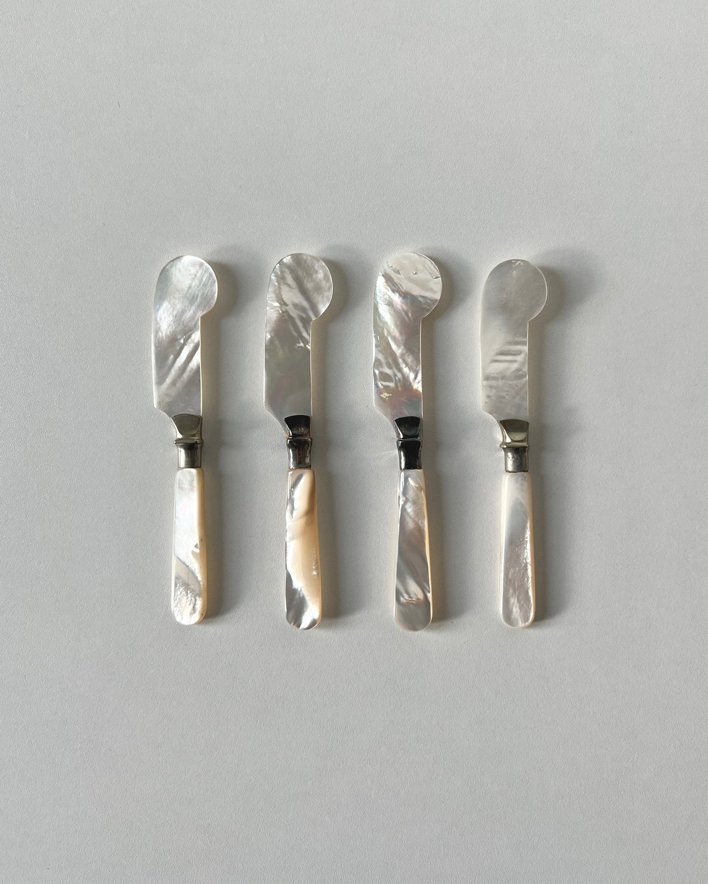 The mother-of-pearl caviar knives, showing the organic, unpolished exterior and natural artistry of the genuine shell form.