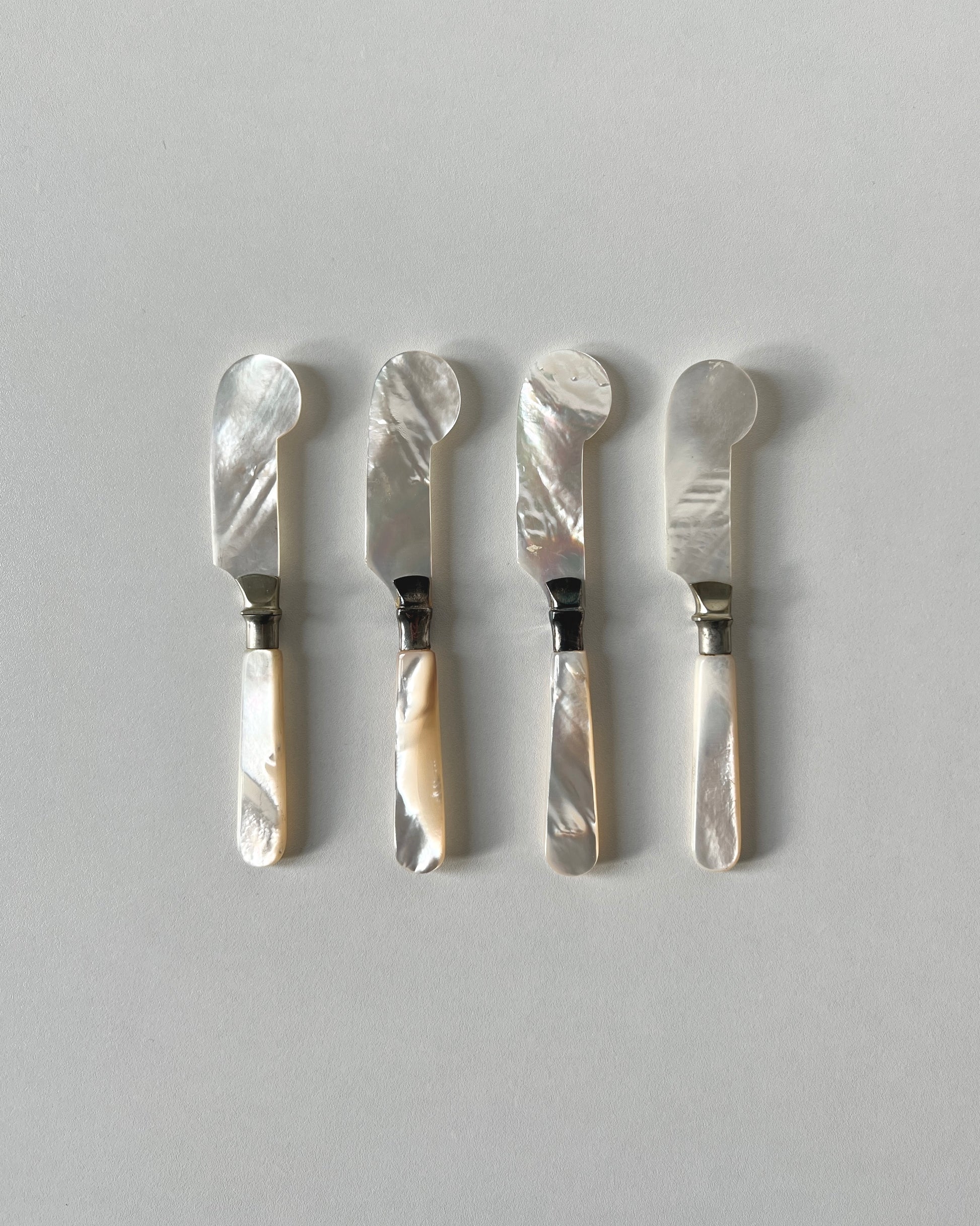 The mother-of-pearl caviar knives, showing the organic, unpolished exterior and natural artistry of the genuine shell form.