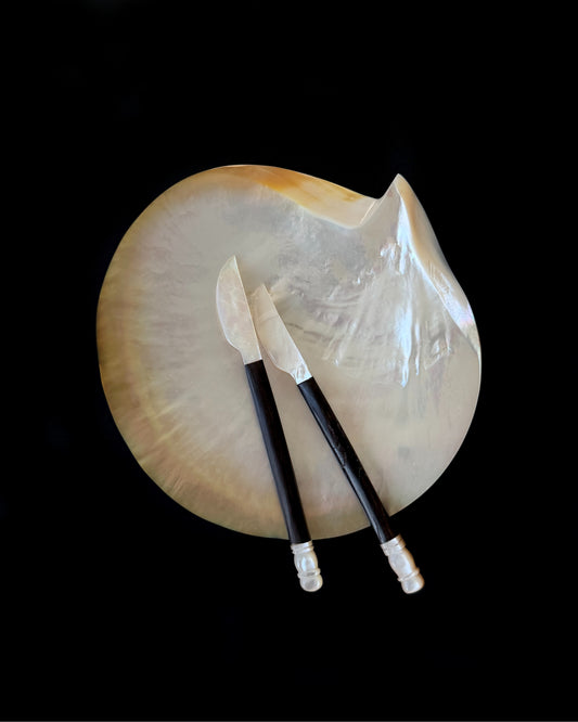 A close-up of the iridescent mother-of-pearl blade, highlighting its non-reactive surface designed to preserve the pure flavor of fine caviar and butters.
