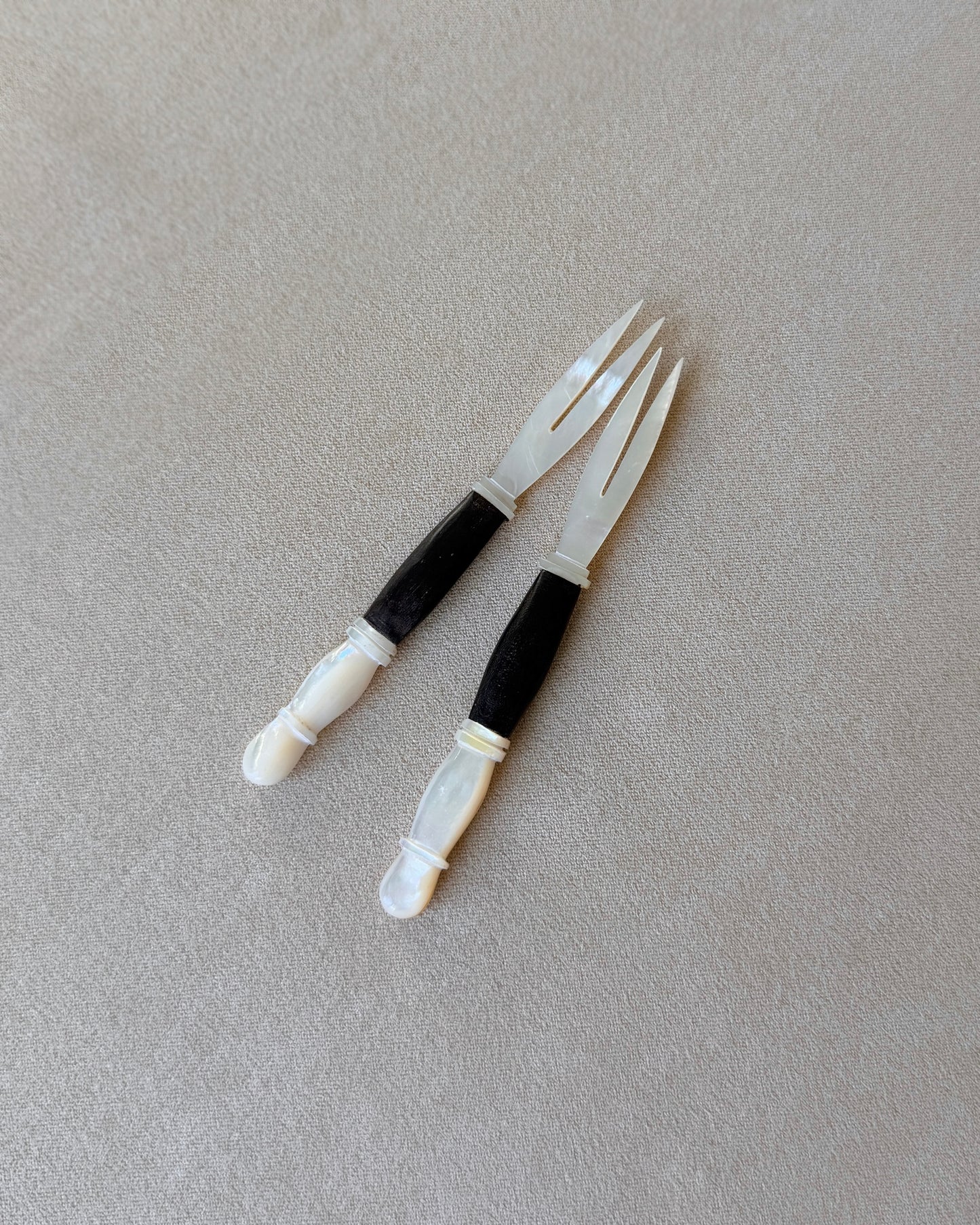 Side view of the vintage appetizer fork showing the elegant transition where the natural shell meets the dark wood, typical of the Organic Modern movement.