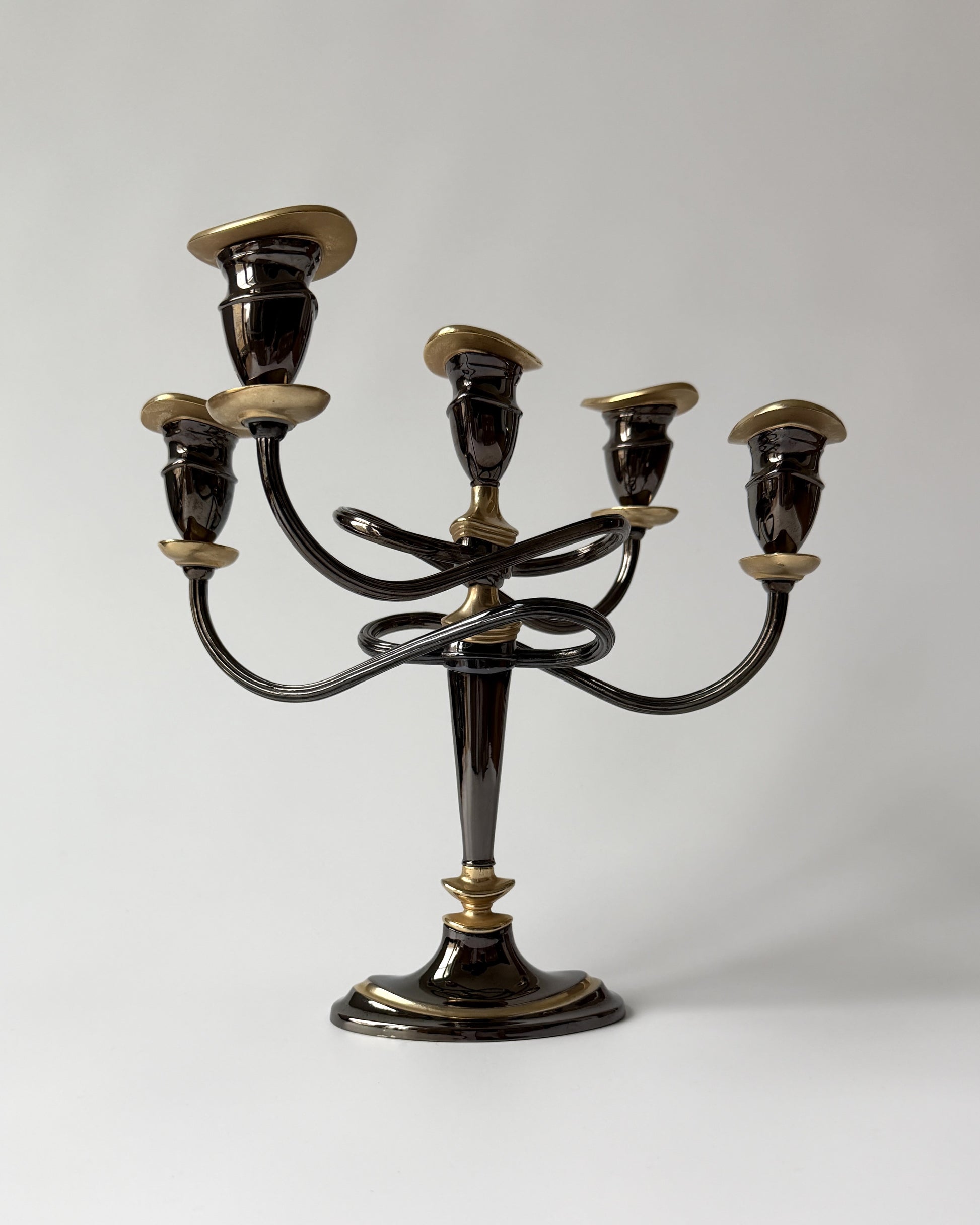 A large vintage five-arm candelabra with elegantly twisted metal arms and a dramatic arc, featuring a dark brown finish with gold-plated accents.