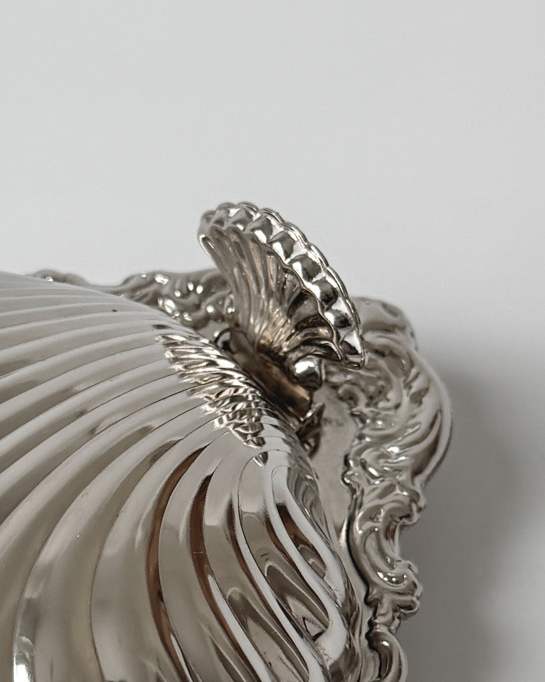 A close-up view of the sculptural scallop shell dish highlighting its brilliant mirror-like silver-plated finish and elegant coastal design.