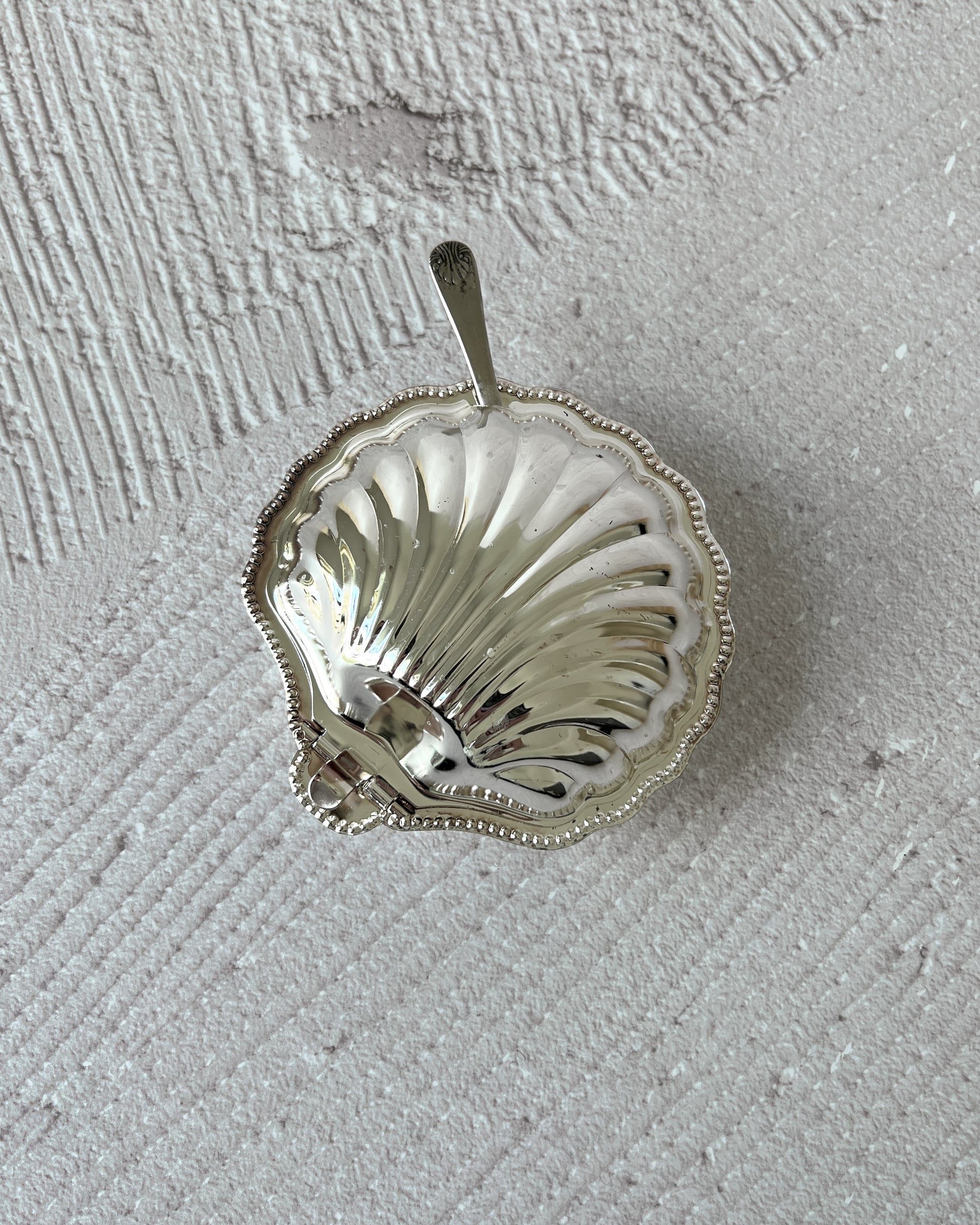 Vintage Sheffield silver-plated shell dish used as a beautiful decorative holder for jewelry, highlighting its versatility beyond serveware.