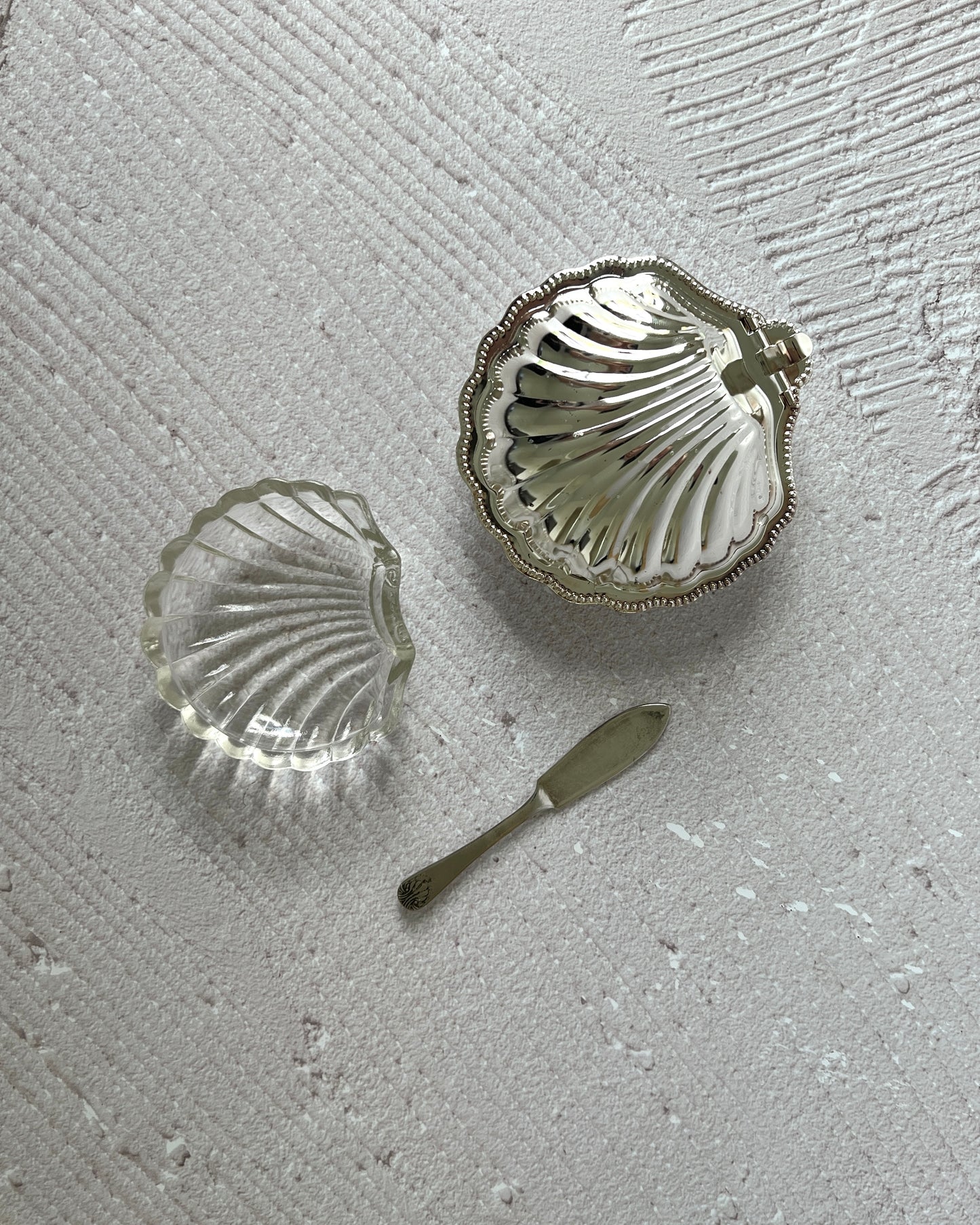 Detailed shot of the matching silver-plated butter knife with a classic shell motif, included with the vintage Sheffield serving dish.