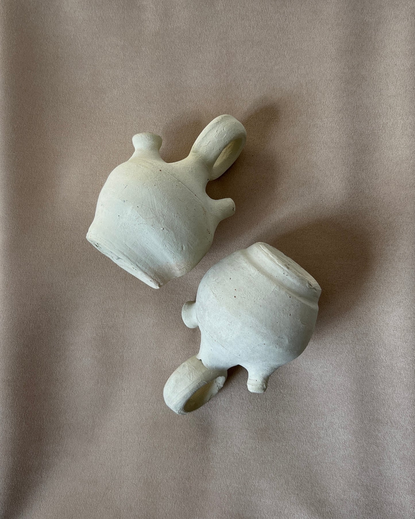 Small Spanish clay botijo jug filled with cool water, beads of condensation forming on its unglazed walls, demonstrating the ancient evaporative cooling method and timeless functionality of this decorative Búcaro pitcher in a modern kitchen setting.