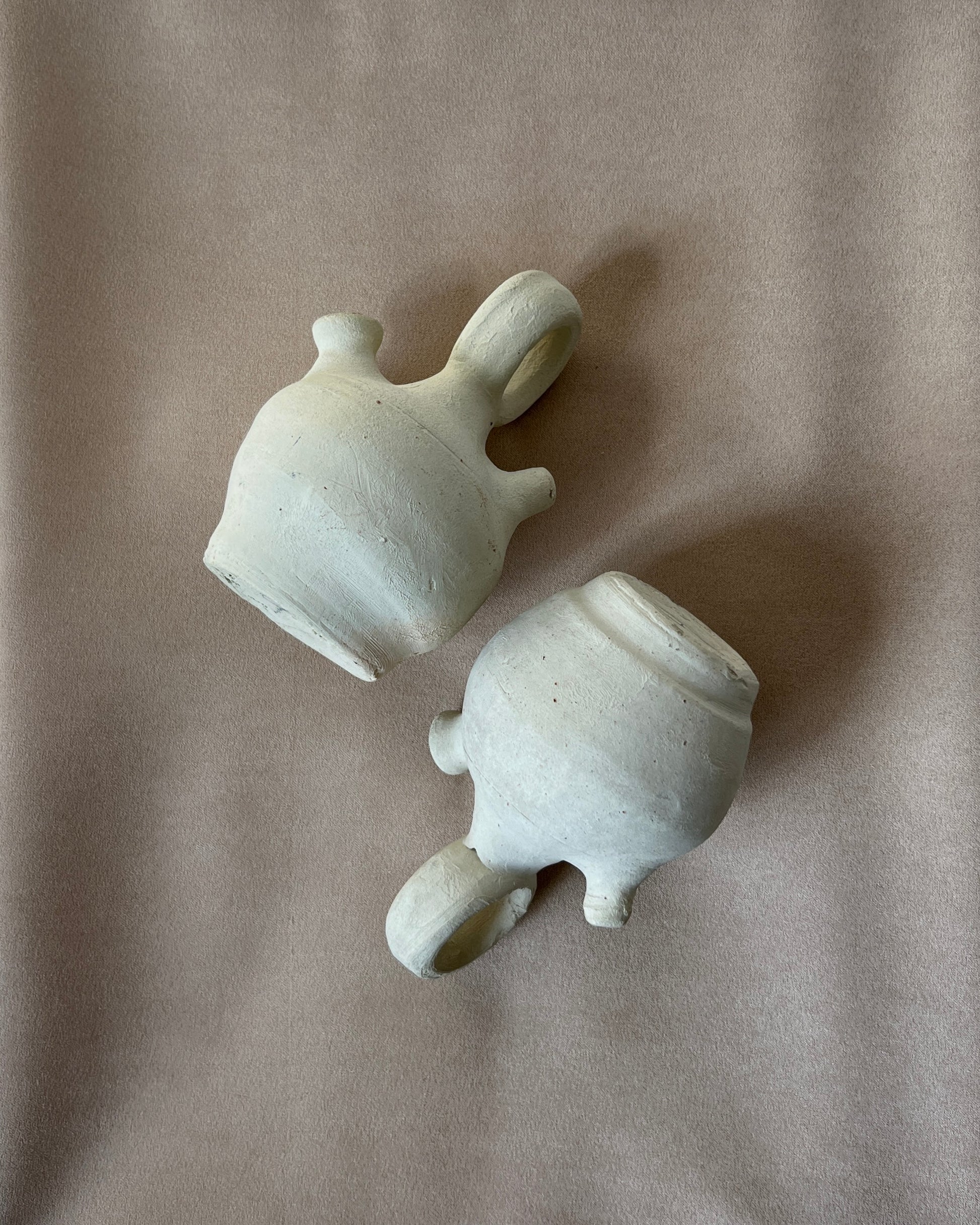 Small Spanish clay botijo jug filled with cool water, beads of condensation forming on its unglazed walls, demonstrating the ancient evaporative cooling method and timeless functionality of this decorative Búcaro pitcher in a modern kitchen setting.