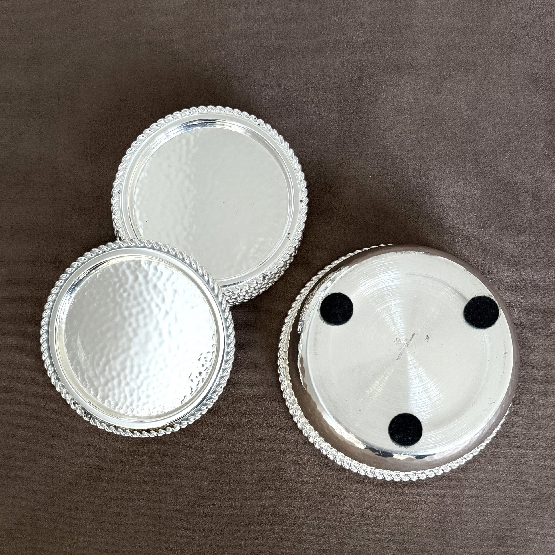 A side profile of the rare West German silver-plated coaster set, showing the significant weight and substantial build of the 1960s barware.