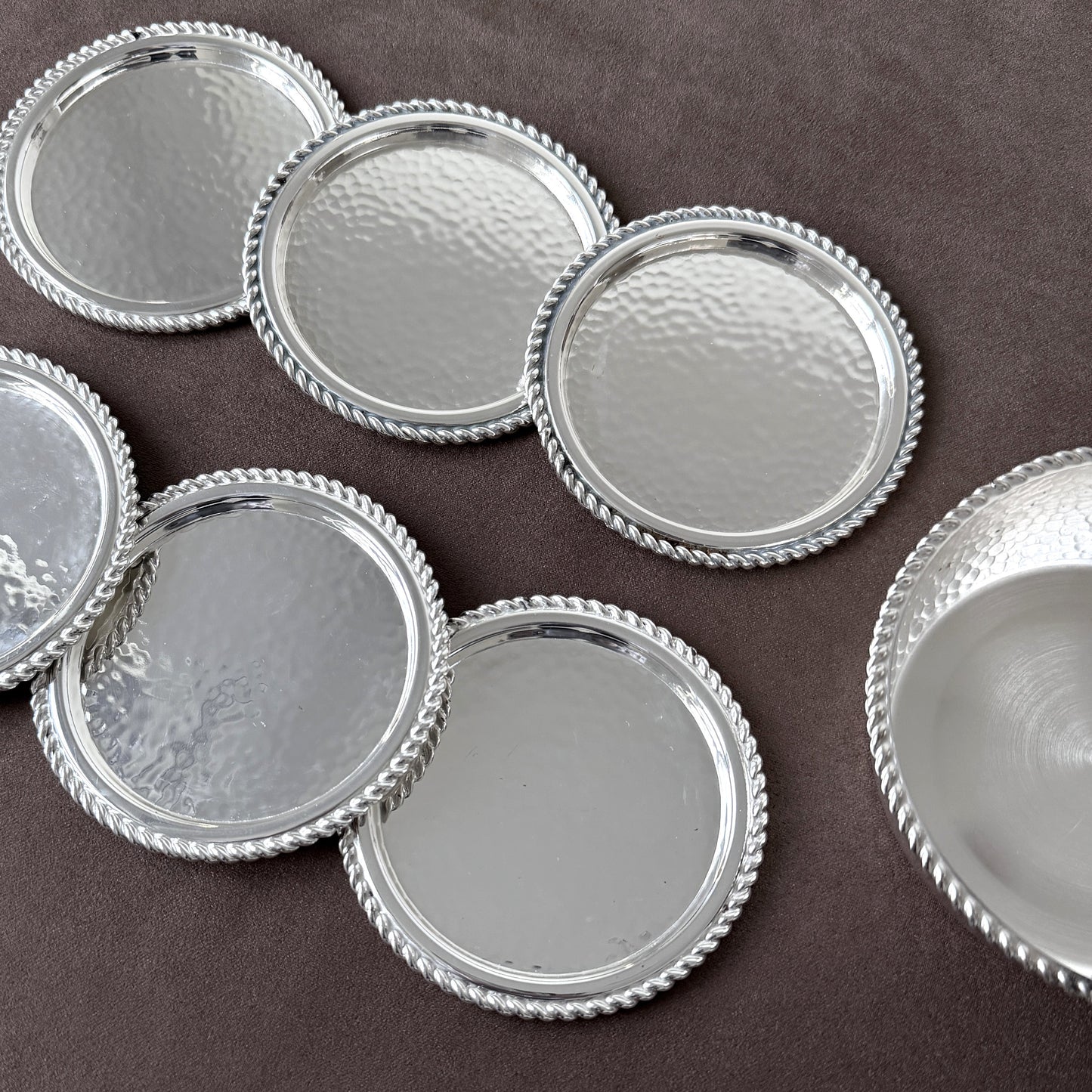 Macro shot of the twisted rope rim and reflective hammered surface, capturing the precision and luxury of German silverplate from the MCM era.