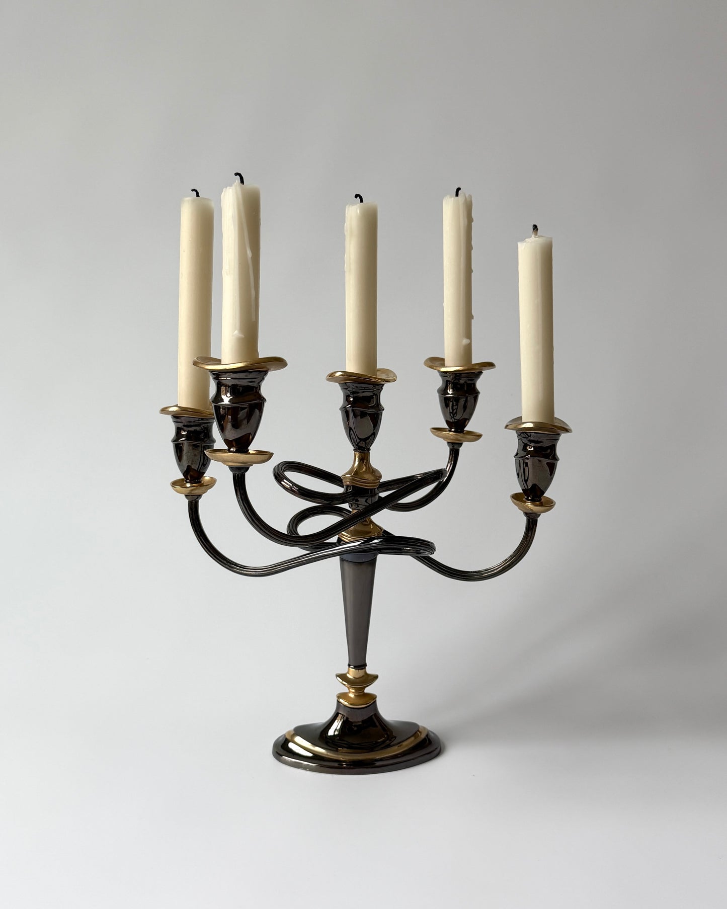 The sculptural 1980s Hollywood Regency candelabra shown with five white taper candles on a neutral white background.
