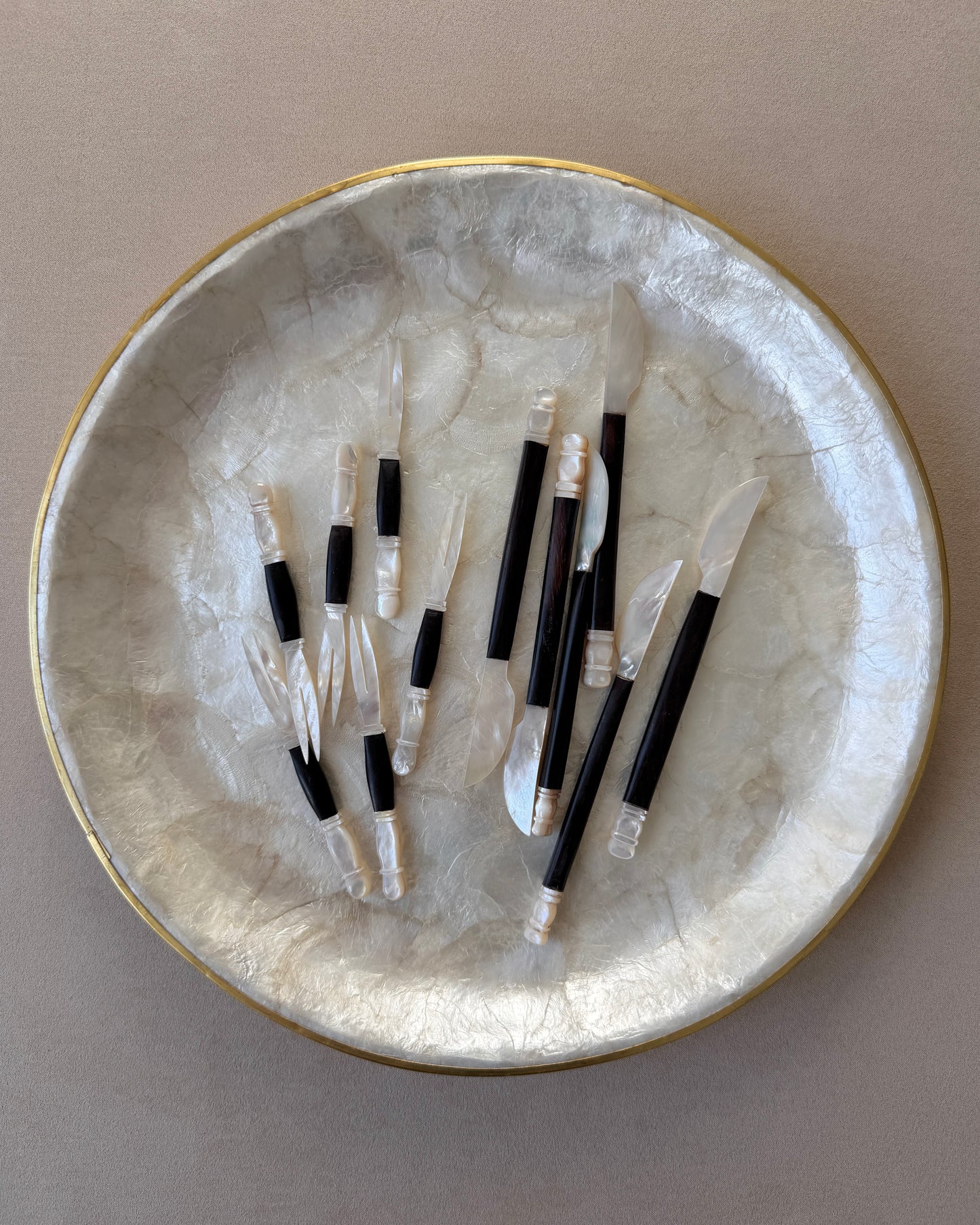 A perspective shot capturing the high-contrast shimmer of the shell against the dark teak grain, perfect for high-end hosting or bar cart decor.