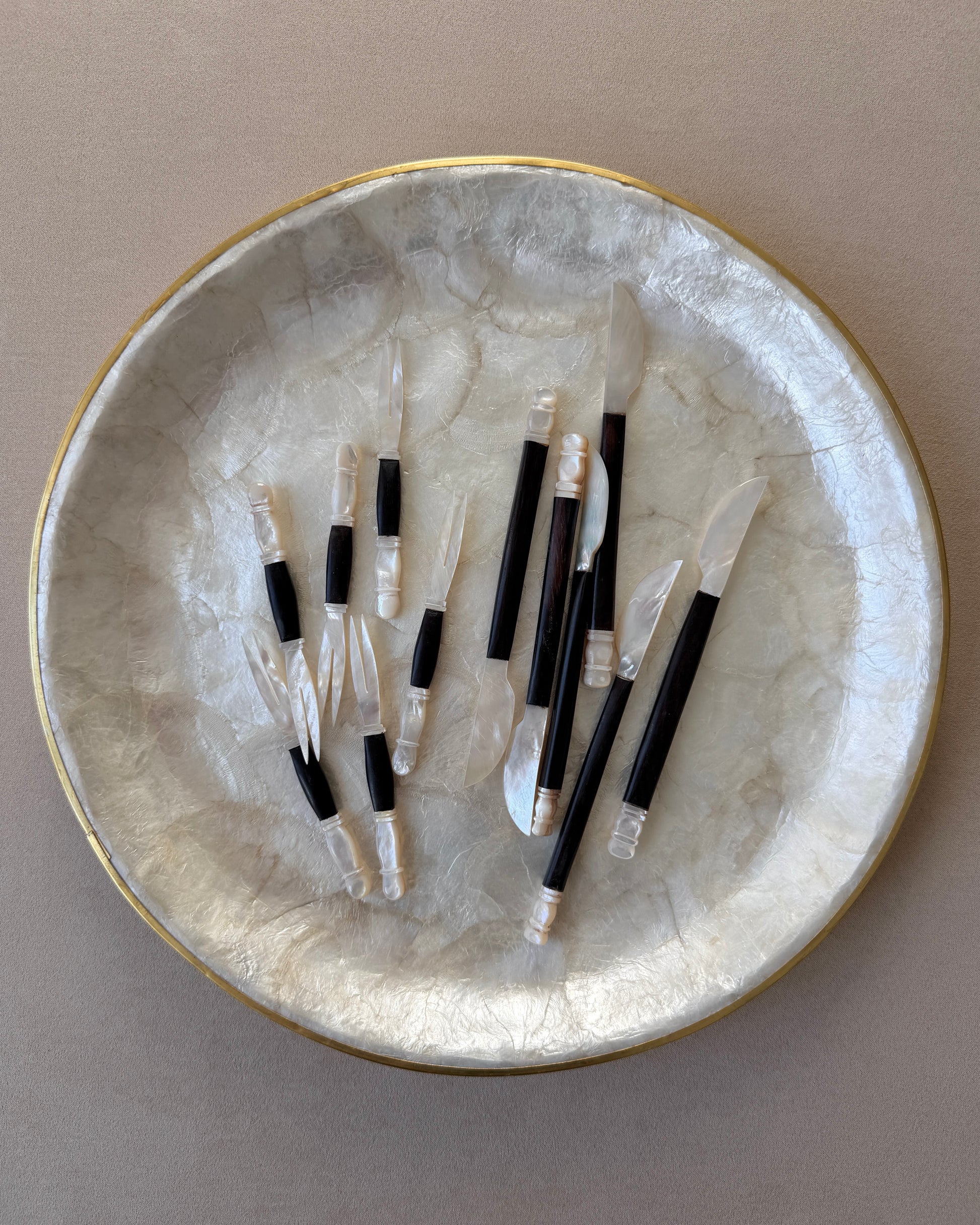 A perspective shot capturing the high-contrast shimmer of the shell against the dark teak grain, perfect for high-end hosting or bar cart decor.