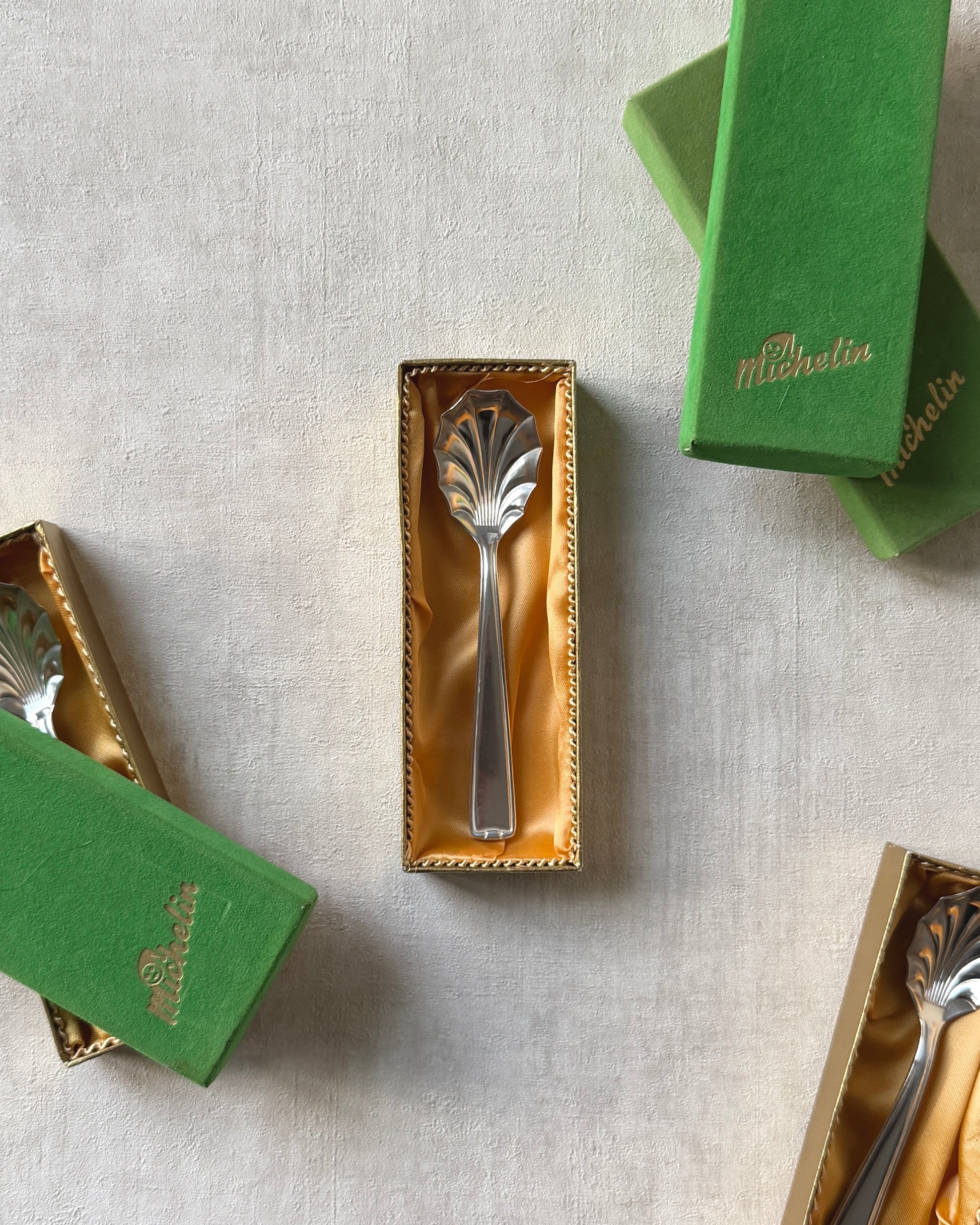 A mid-century Michelin silver-plated shell spoon presented in its original vintage box, perfect for collectors of refined German silverware.