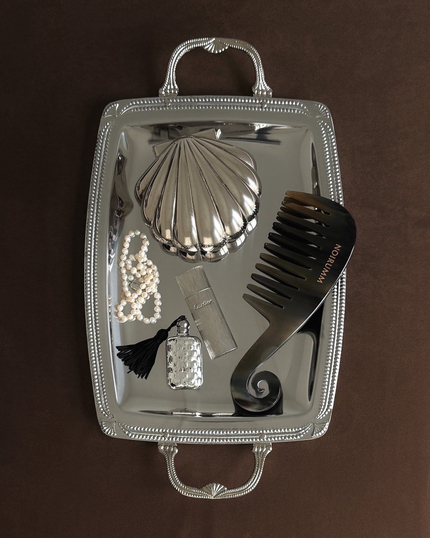 A full view of a mid-20th-century silver-plated tray featuring elegantly cast scallop shell handles, perfect for a luxury bar cart or coastal coffee table.