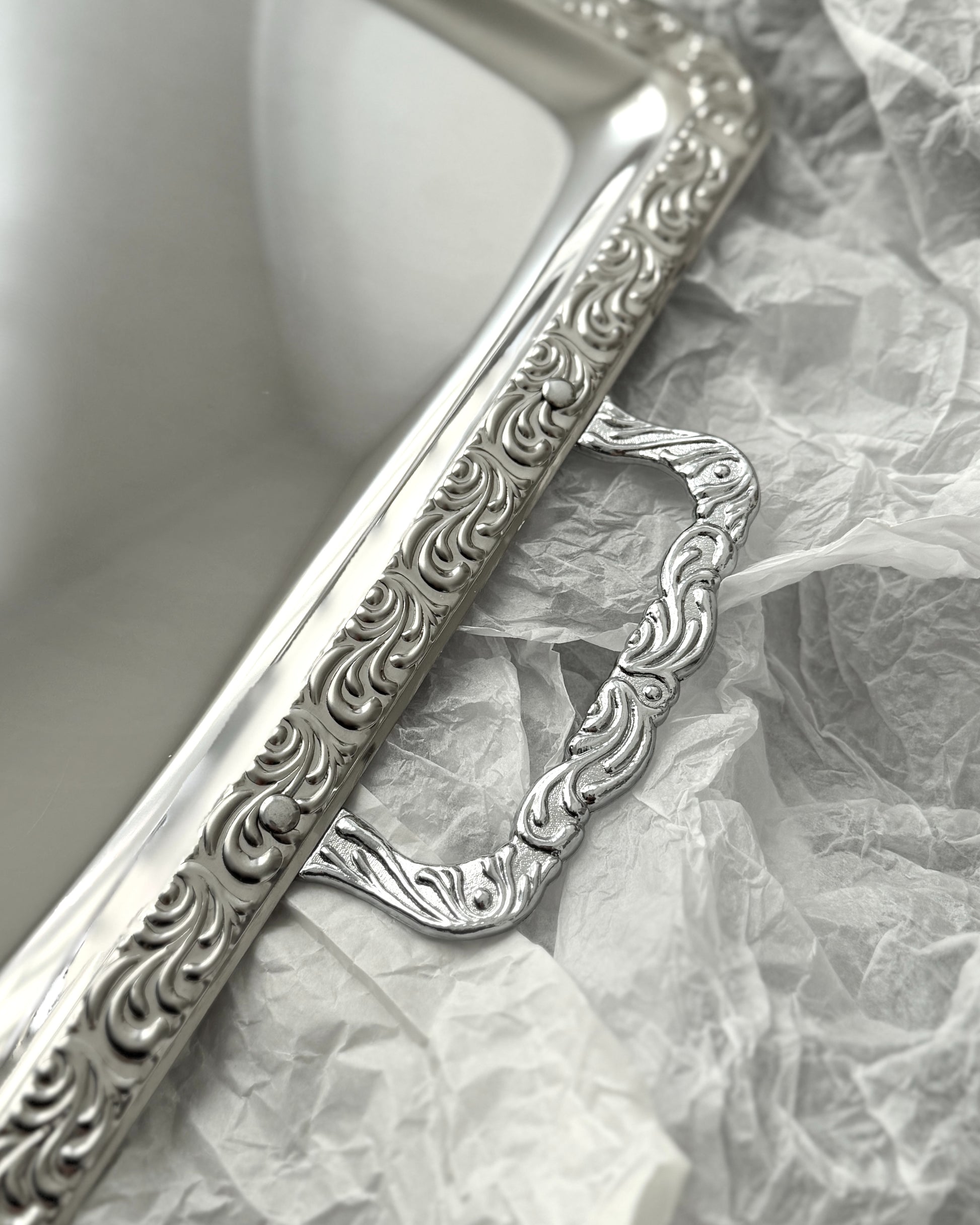 Close-up view of the intricate decorative detailing on the handles and rim of the XL West German stainless steel platter, showing the blend of traditional and modern design.
