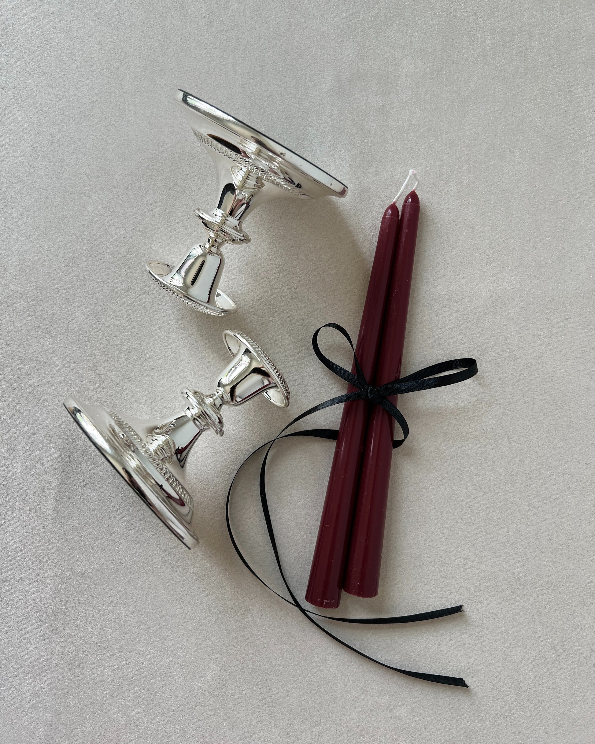Close‑up of mid‑century silver‑plated candlestick silhouette showcasing elegant tapered profile and reflective finish.