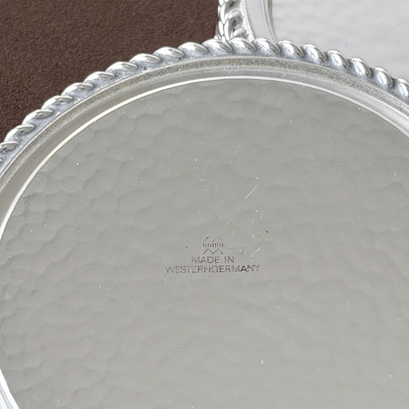 The underside of a hammered silver coaster, illustrating the quality craftsmanship and West German origin of this vintage 1960s collector's set.